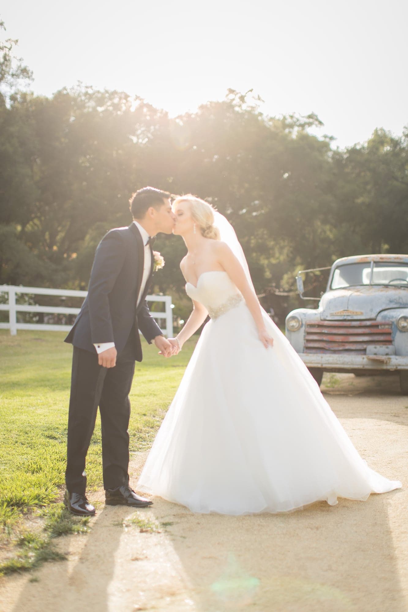 Krista and Oscar in golden light beside a vintage truck