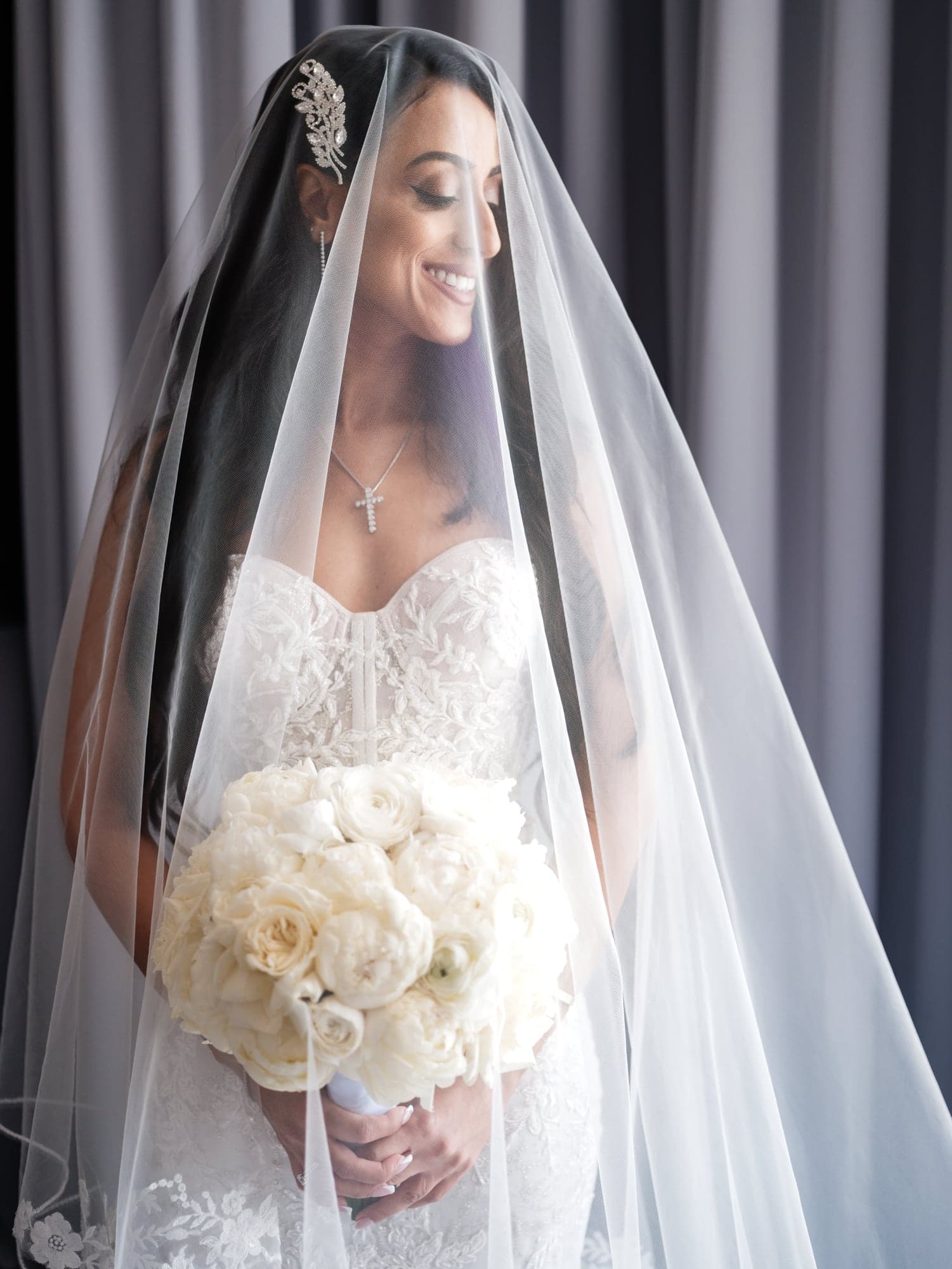 Vivian holding her bouquet beneath her veil before entering the Coptic Orthodox church