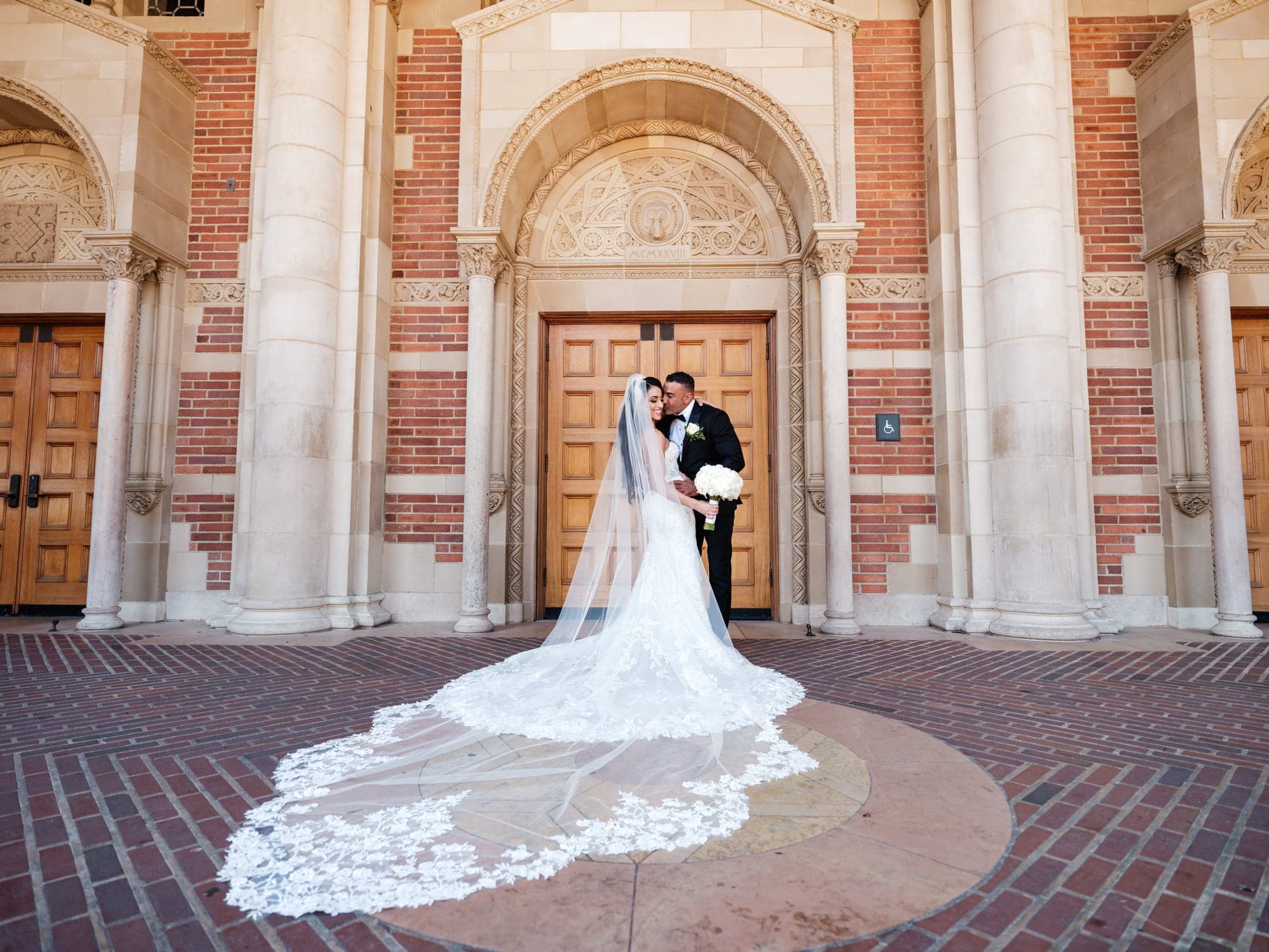 Vivian and Sherif standing together on an ornate stone staircase after their Coptic Orthodox wedding ceremony