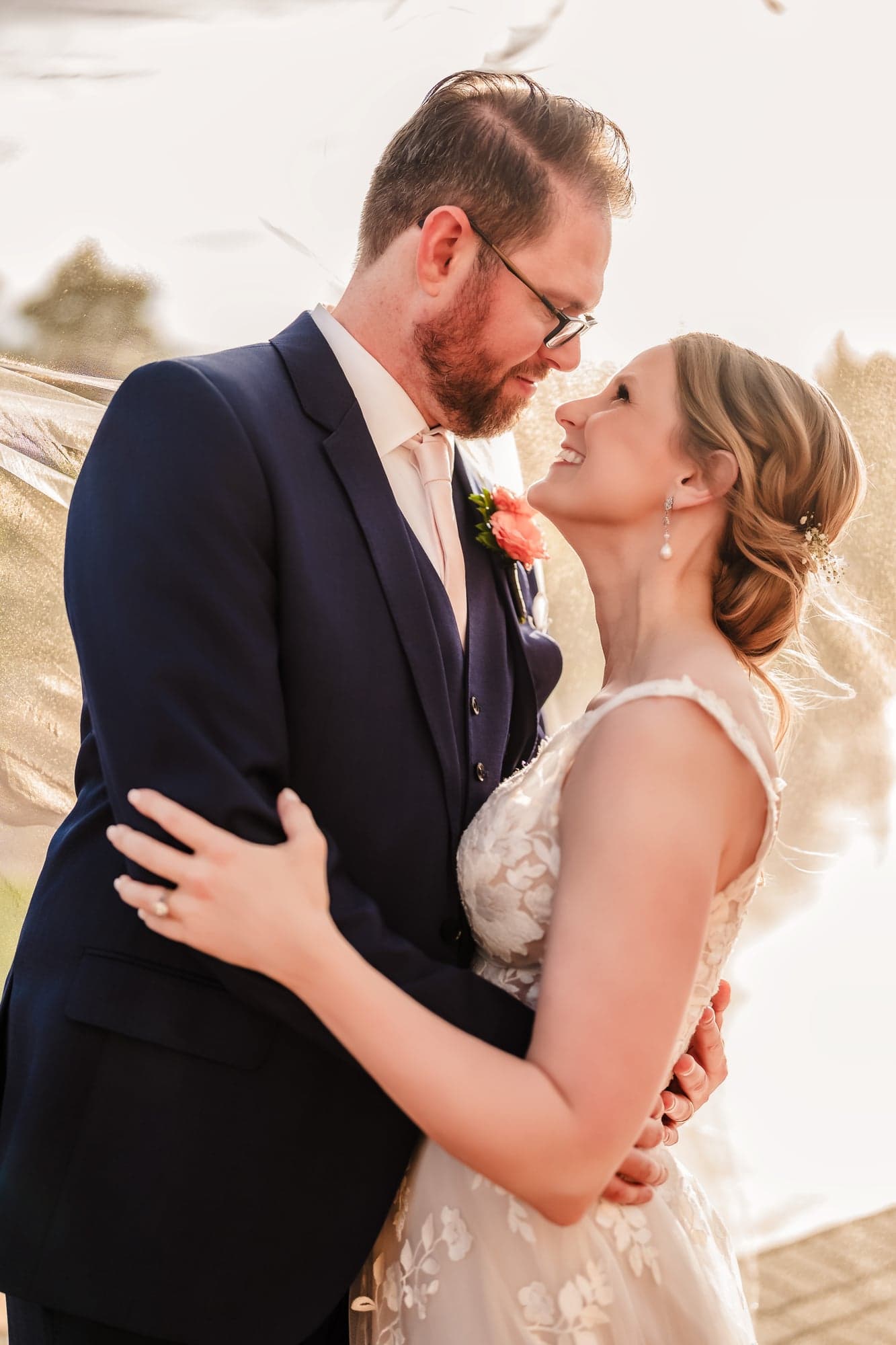 Erin and Hunter close together in backlit golden hour light beside the fountain at D'Vine Grace Vineyard
