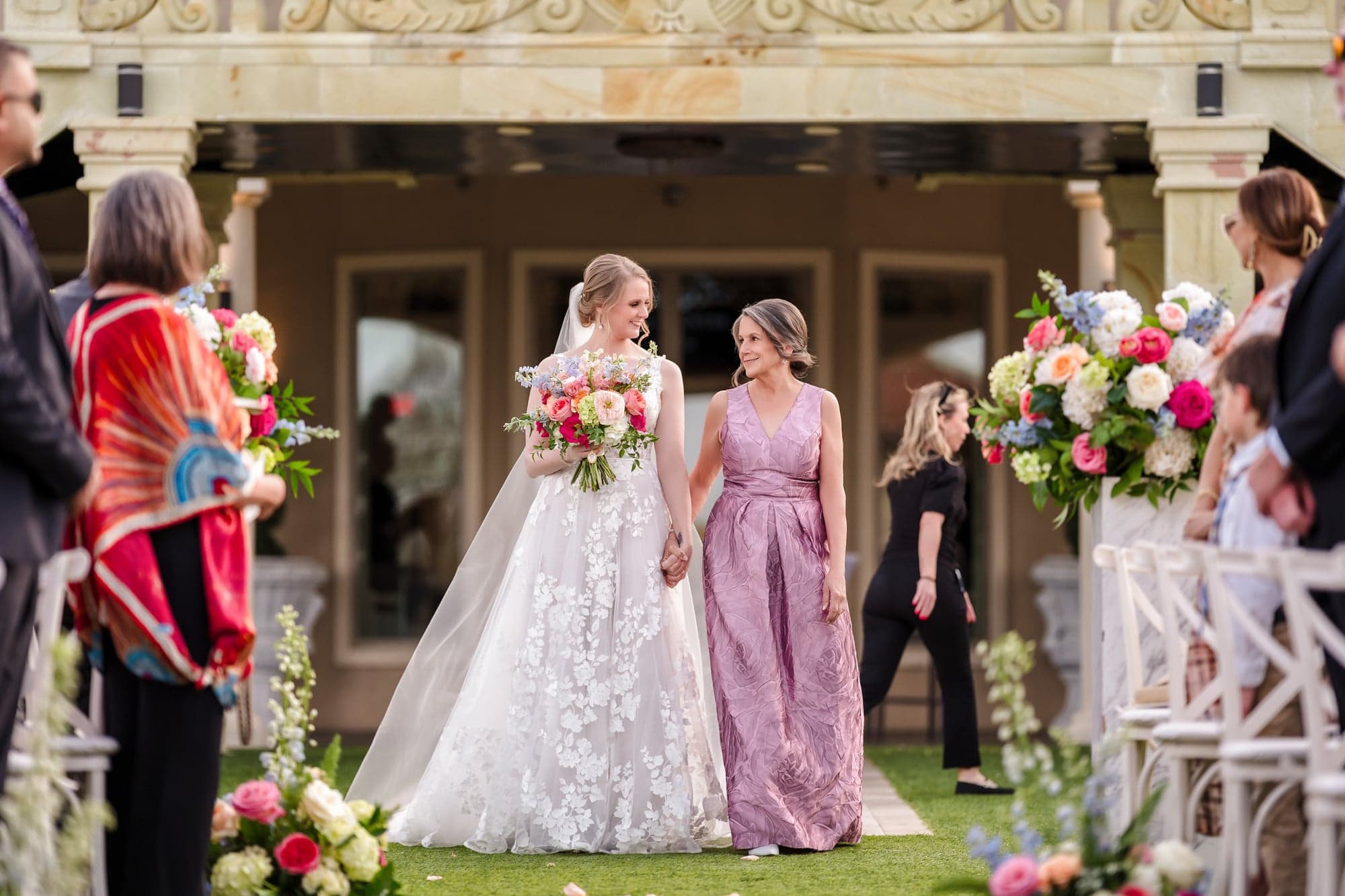 Erin walking down the aisle hand in hand with guests standing on both sides