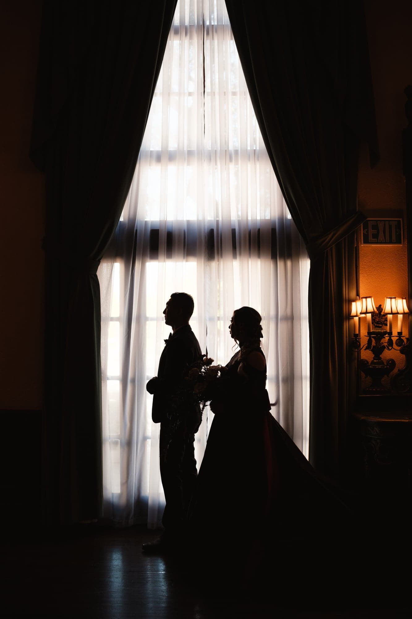 Alda and Kevin silhouetted together against a tall window