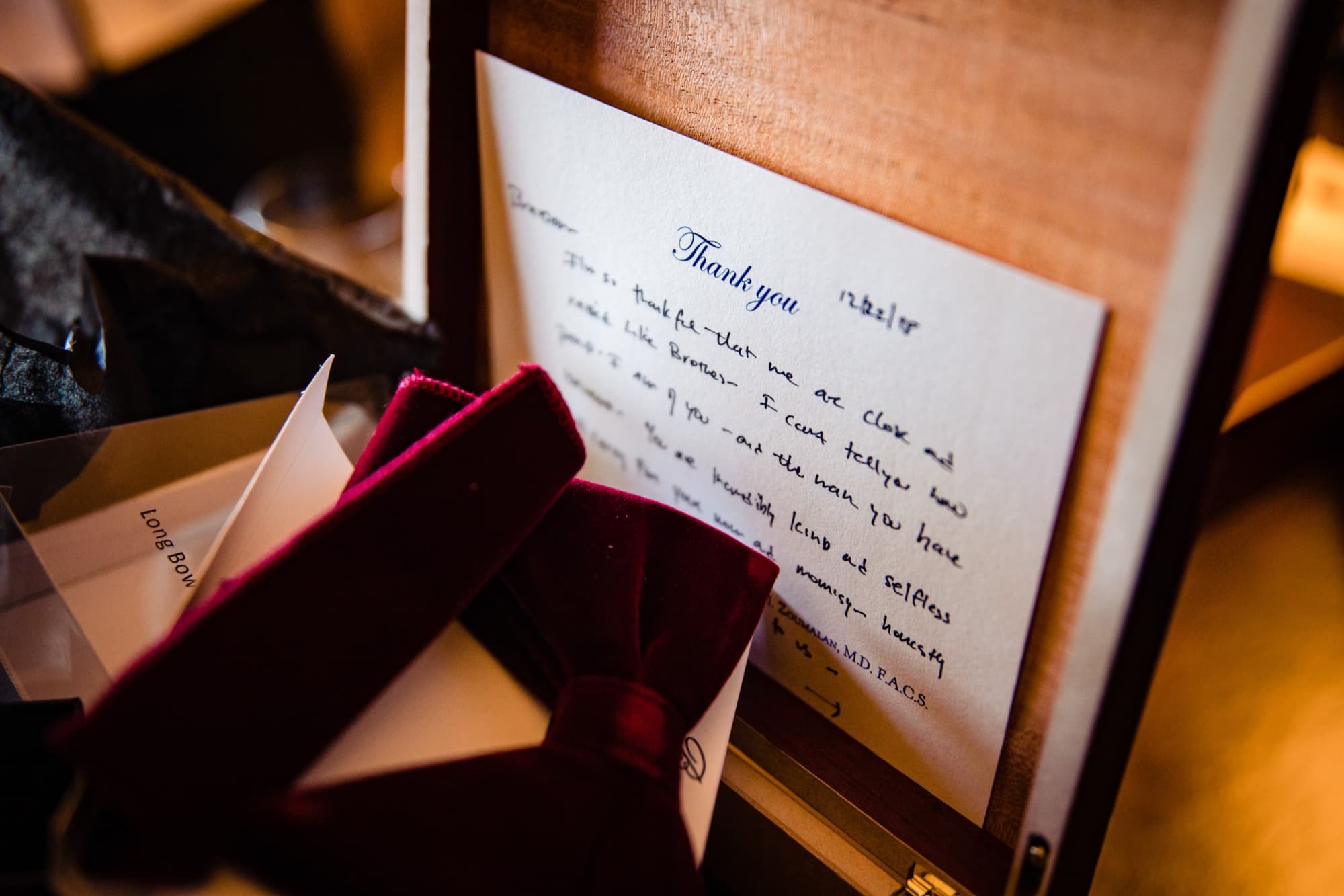 A handwritten thank-you note beside burgundy velvet ring boxes during getting-ready at the Fairmont Grand Del Mar
