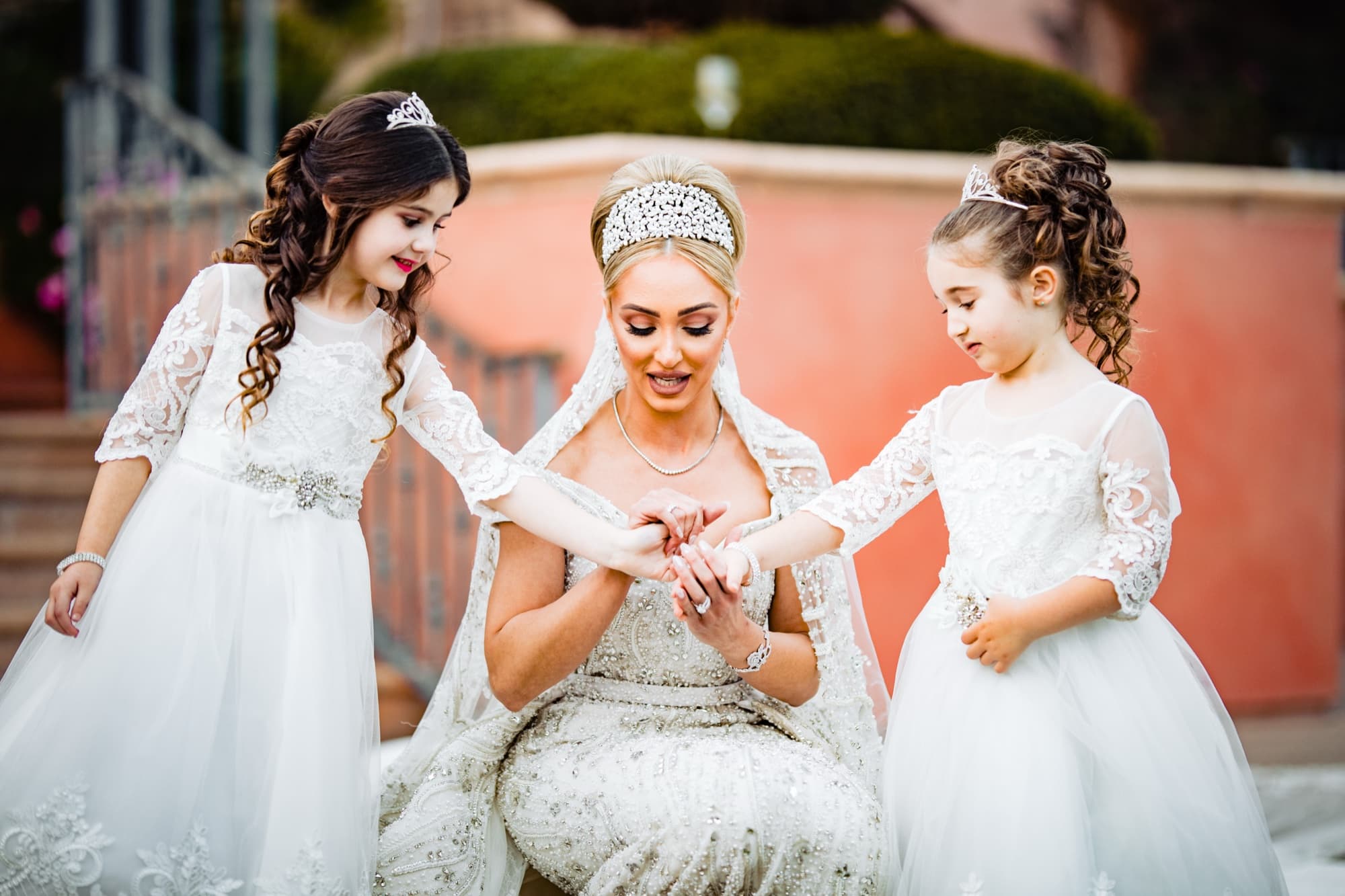 Rhonda in her crown seated with two flower girls in lace gowns and crowns at the Fairmont Grand Del Mar