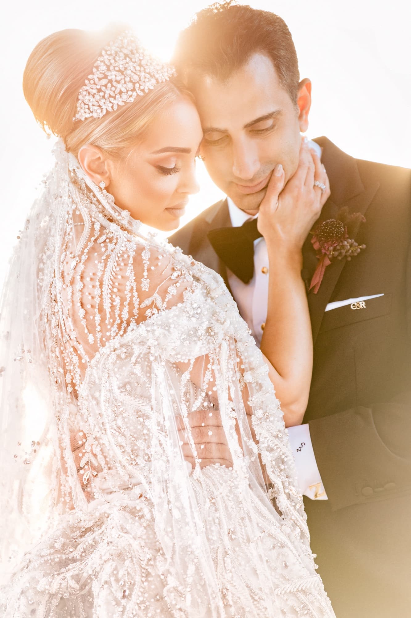 Close portrait of Rhonda in her beaded couture cape and crown resting her head against Christopher