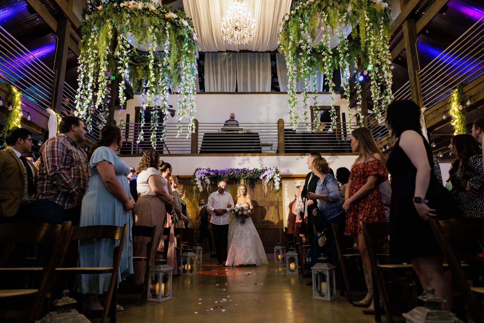 Amber and Joshua's ceremony inside The Barn at Fiddle Dee Farms beneath chandeliers and greenery