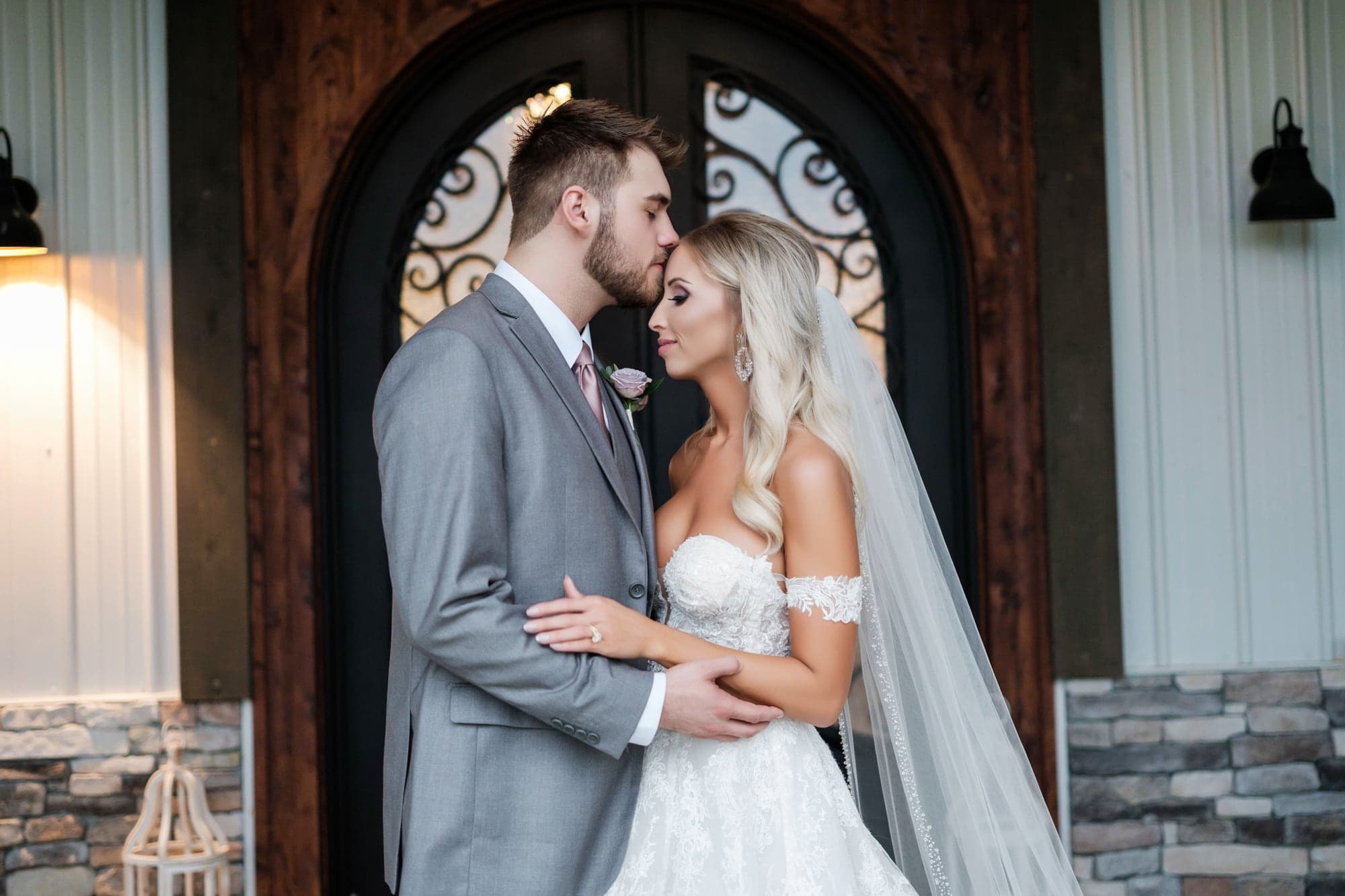 Amber and Joshua sharing a portrait in the arched entrance at Fiddle Dee Farms