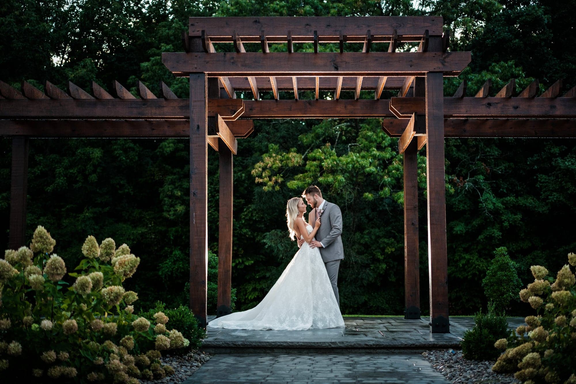 Amber and Joshua walking together through the formal garden at Fiddle Dee Farms