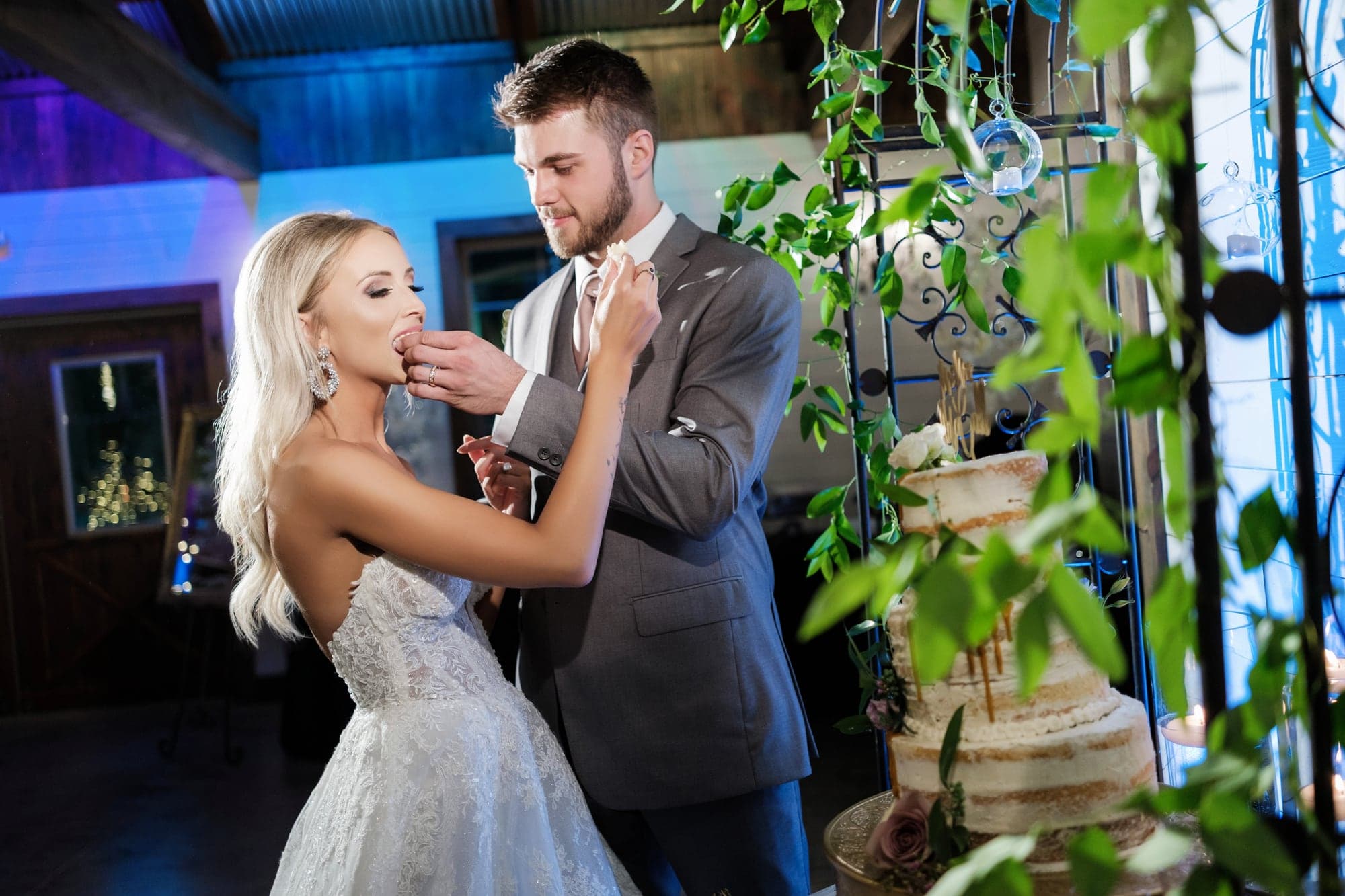 Amber and Joshua sharing their first dance beneath warm reception lights and greenery