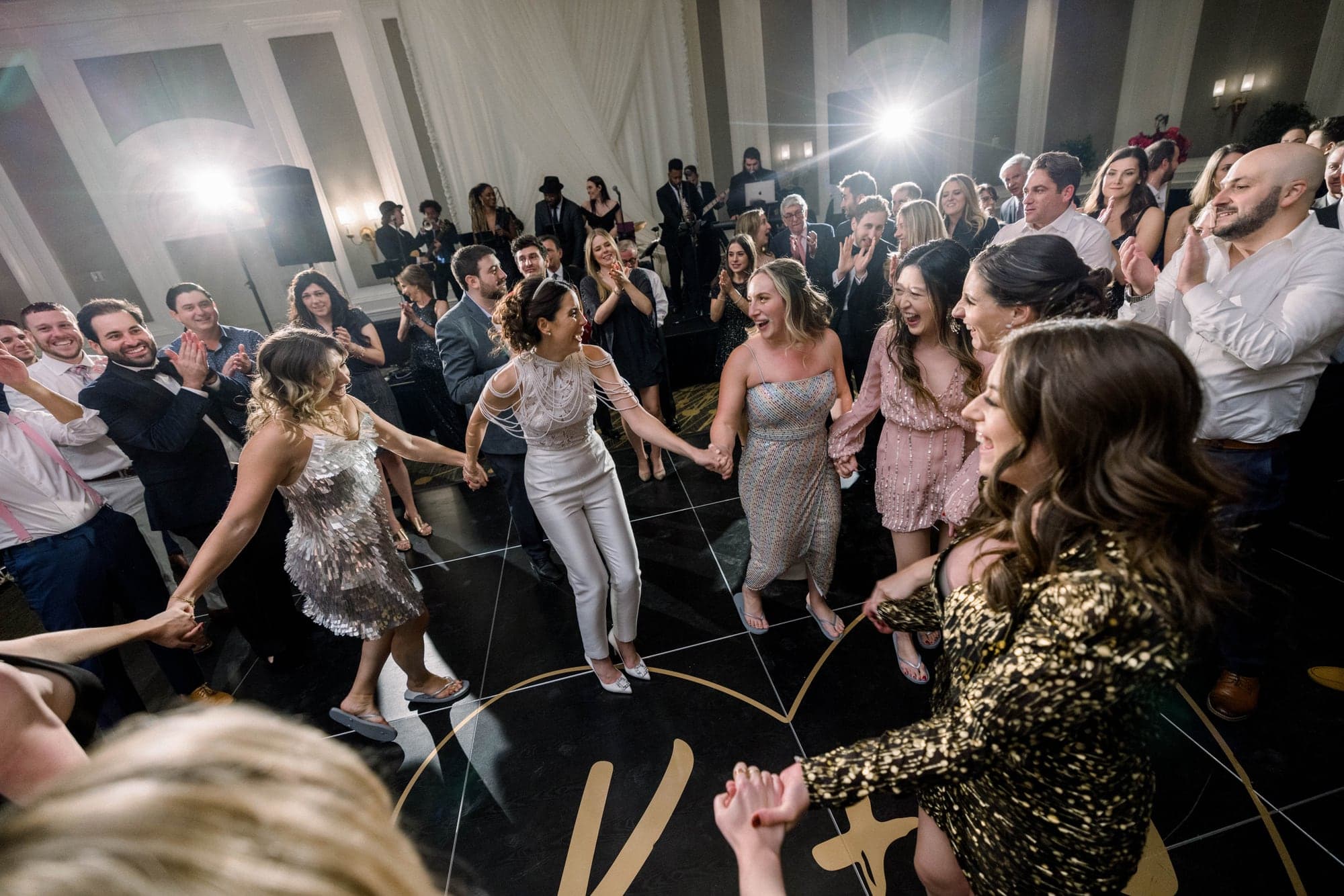 Guests surrounding Kylie and Jason on the crowded ballroom dance floor