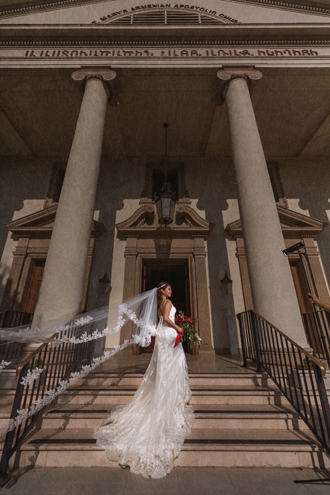 Angela on the columned steps of St. Mary's Armenian Apostolic Church, her lace veil cascading down the staircase