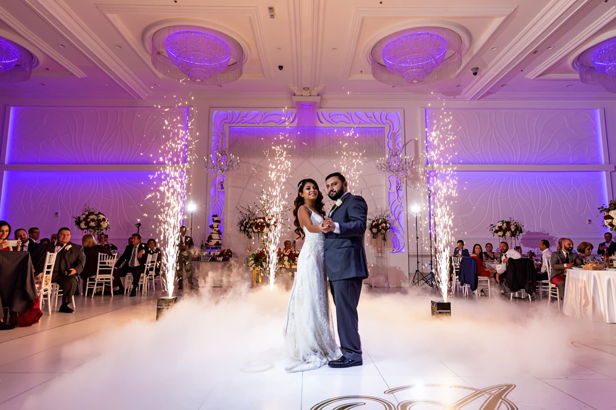 Angela and Arthur's first dance on a fog-covered floor as cold spark fountains erupt around them at The Great Caesar's Banquet Hall