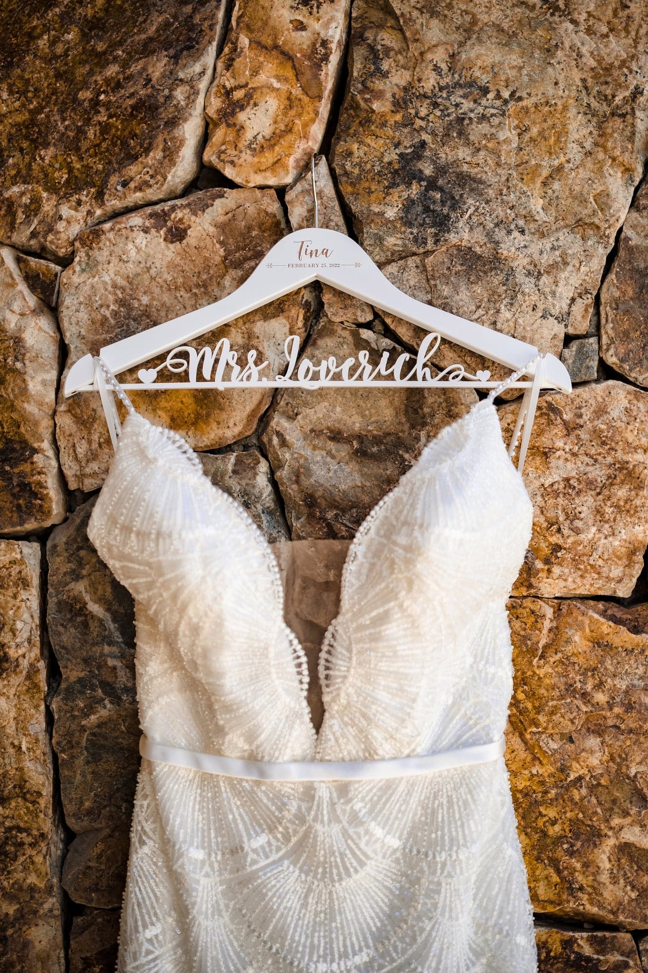 Tina's wedding gown hanging against the warm stone architecture at Grand Solmar