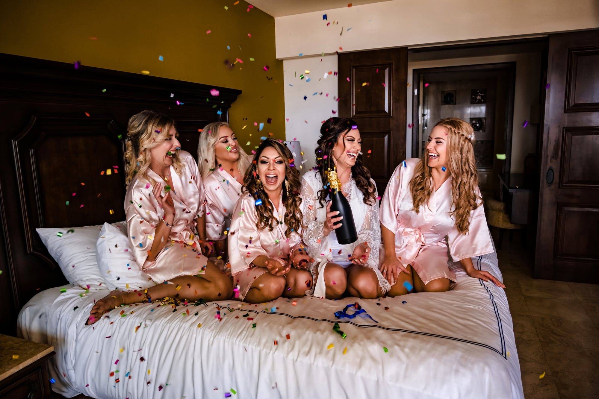Tina celebrating with her bridesmaids in coral dresses before the Cabo ceremony