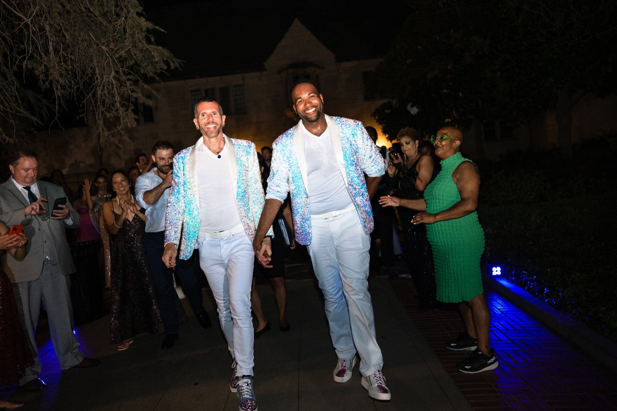 CJ and Rex entering their reception together beneath the evening lights