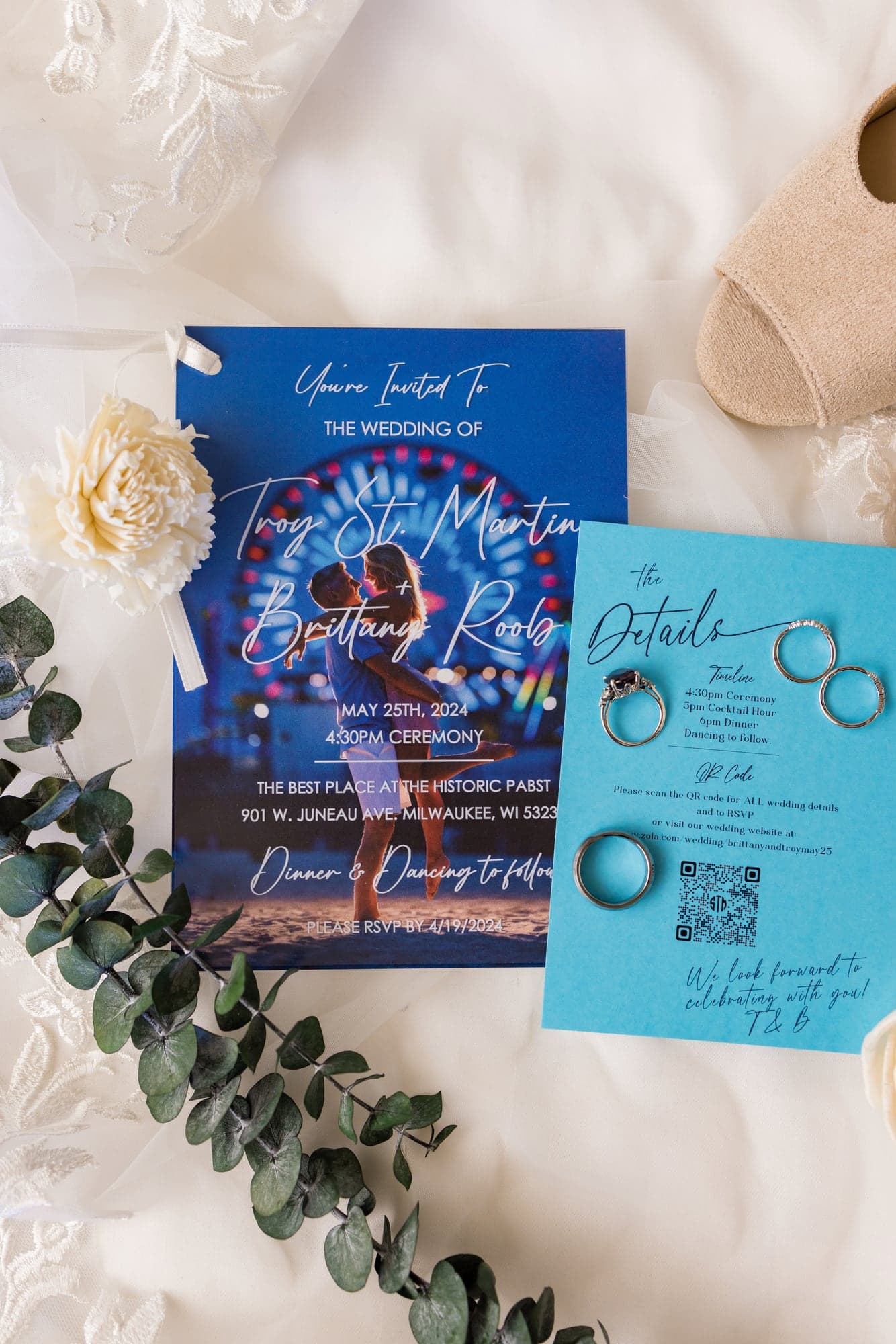 Brittany and Troy's blue Milwaukee wedding invitation and rings