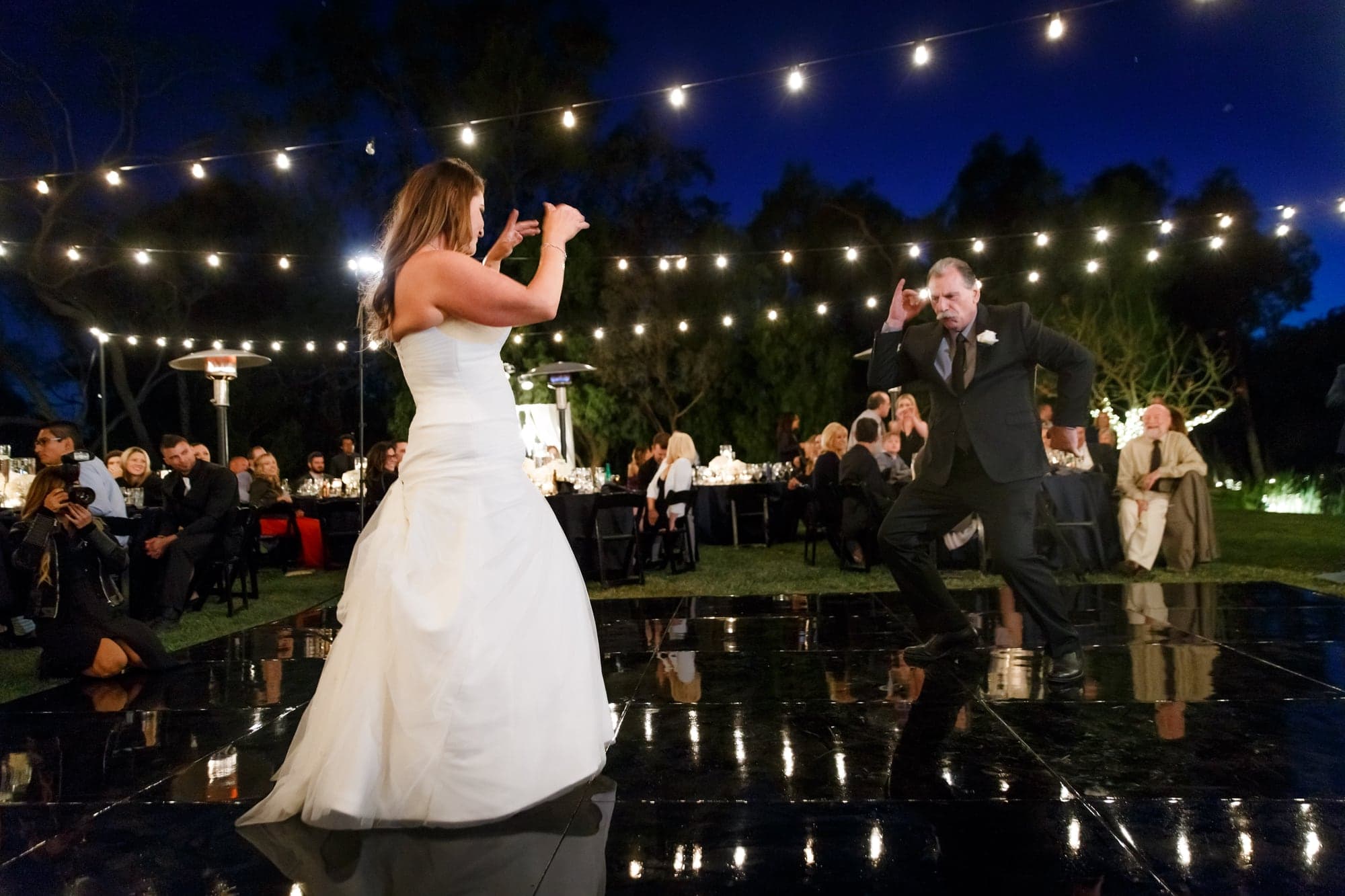 The newlyweds celebrating beneath string lights