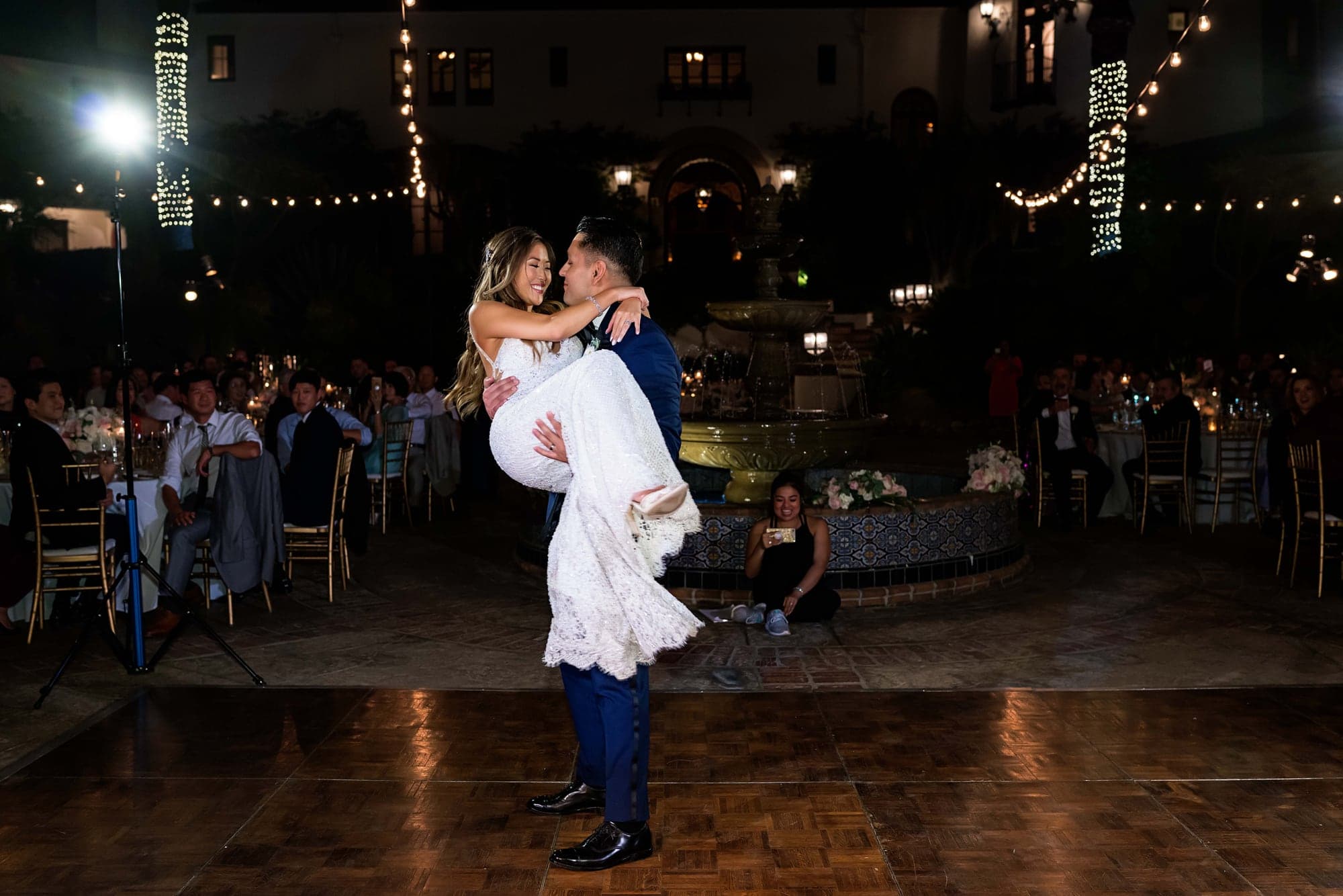 Stephanie and Lauro dancing beneath string lights