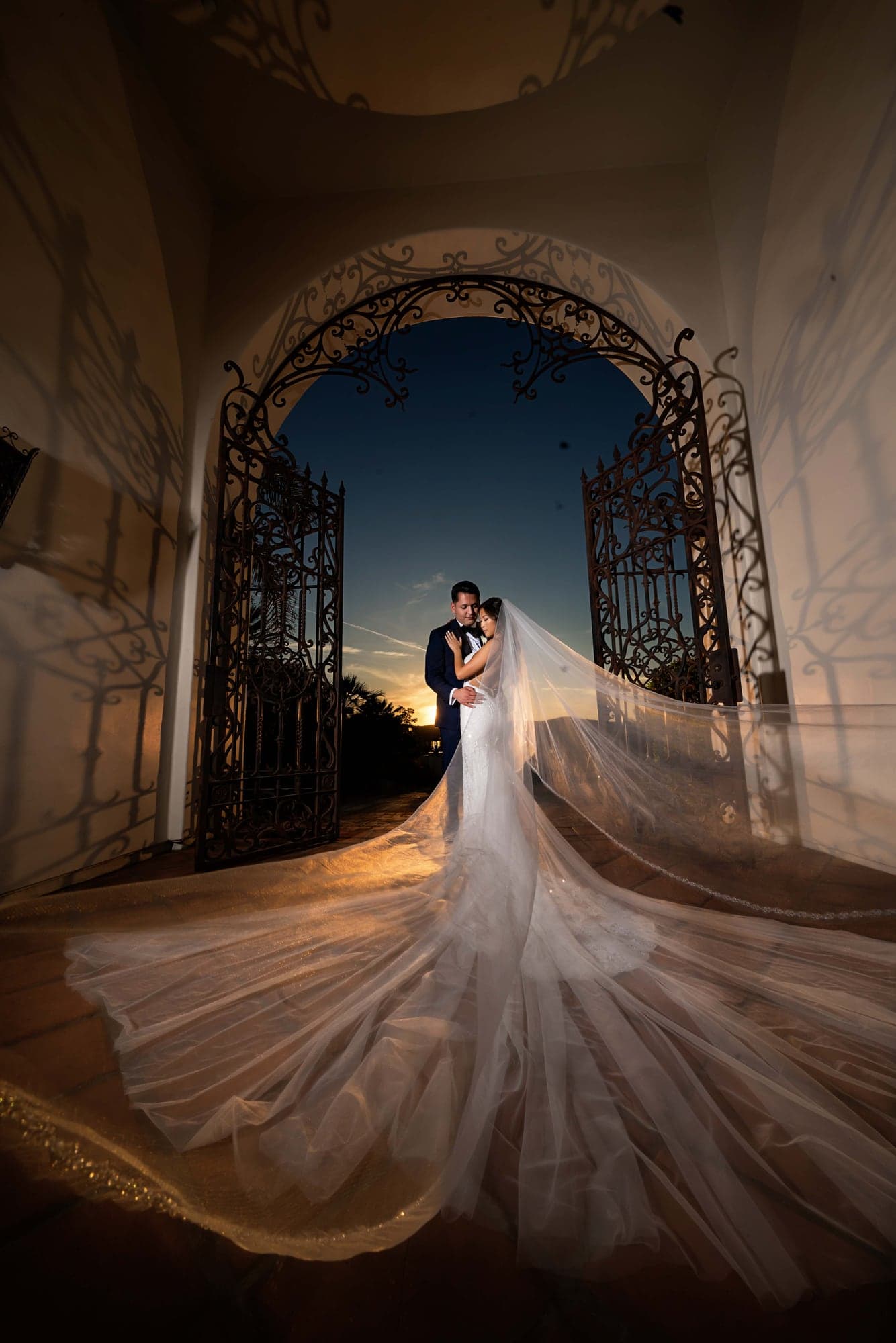 Nighttime veil portrait beneath the Villa's iron gates