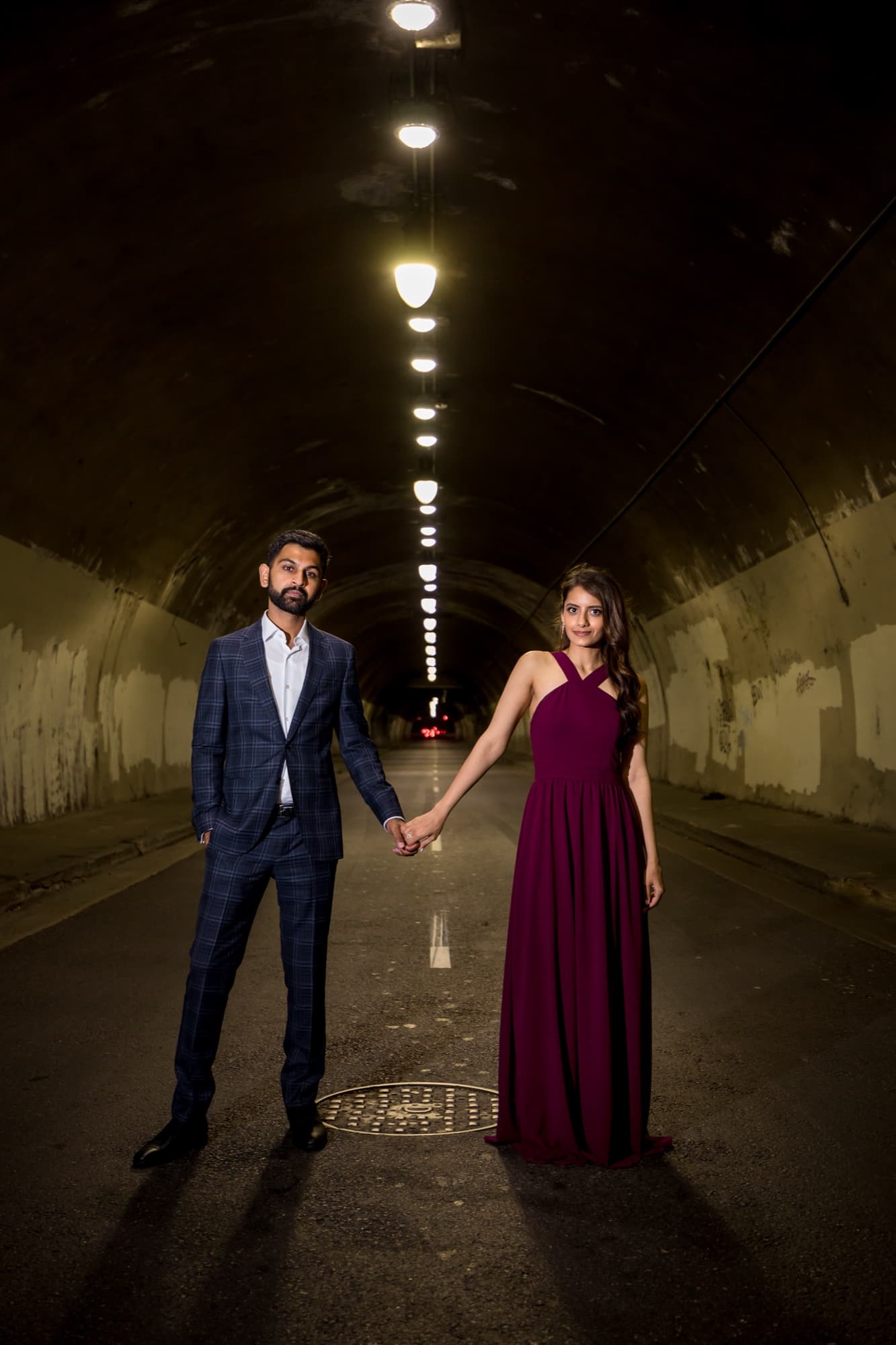 Noor and Sheazad holding hands down the centerline of the empty Second Street tunnel in downtown Los Angeles