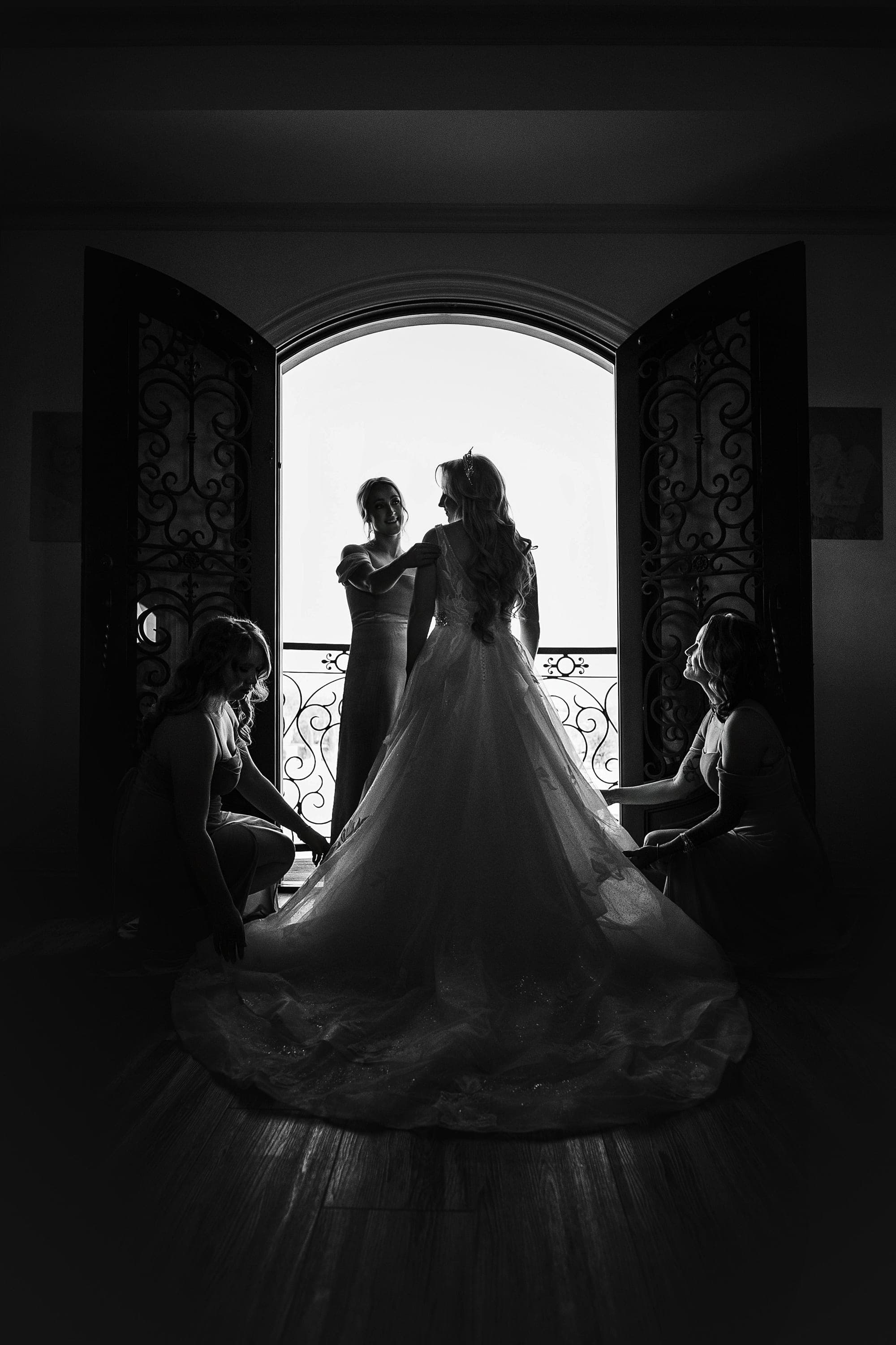 Carly silhouetted in the arched balcony doors, her train spilling down the steps