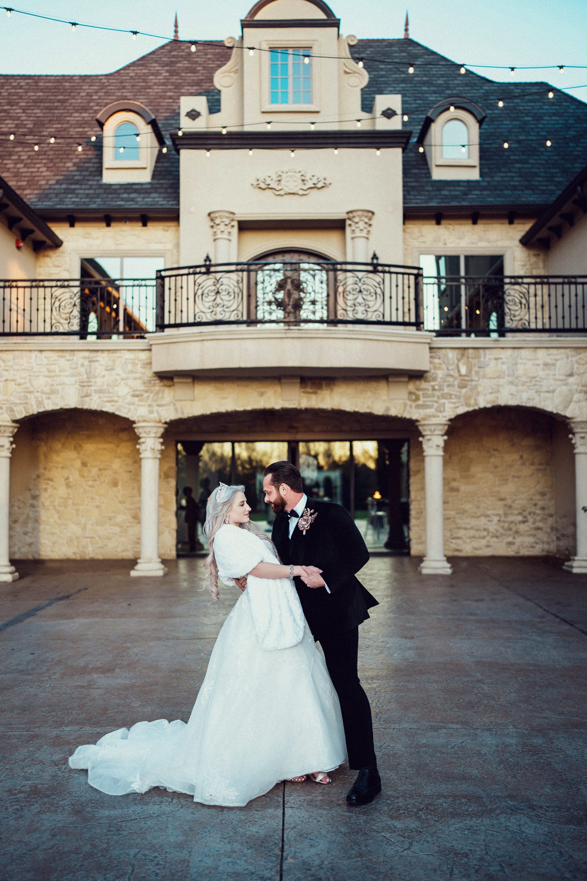 The couple in front of the French château facade at Knotting Hill Place