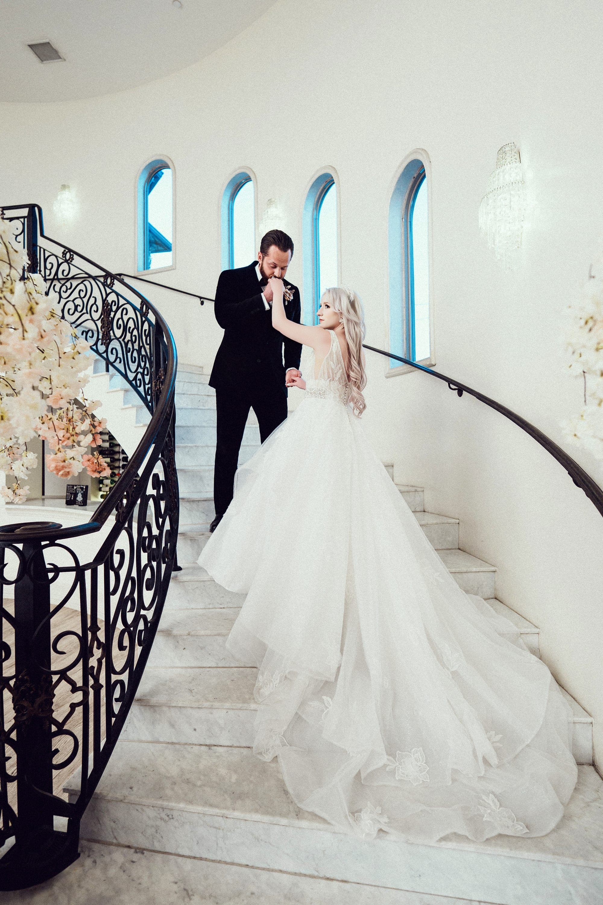 Carly's gown trailing down the grand staircase as Christopher kisses her hand