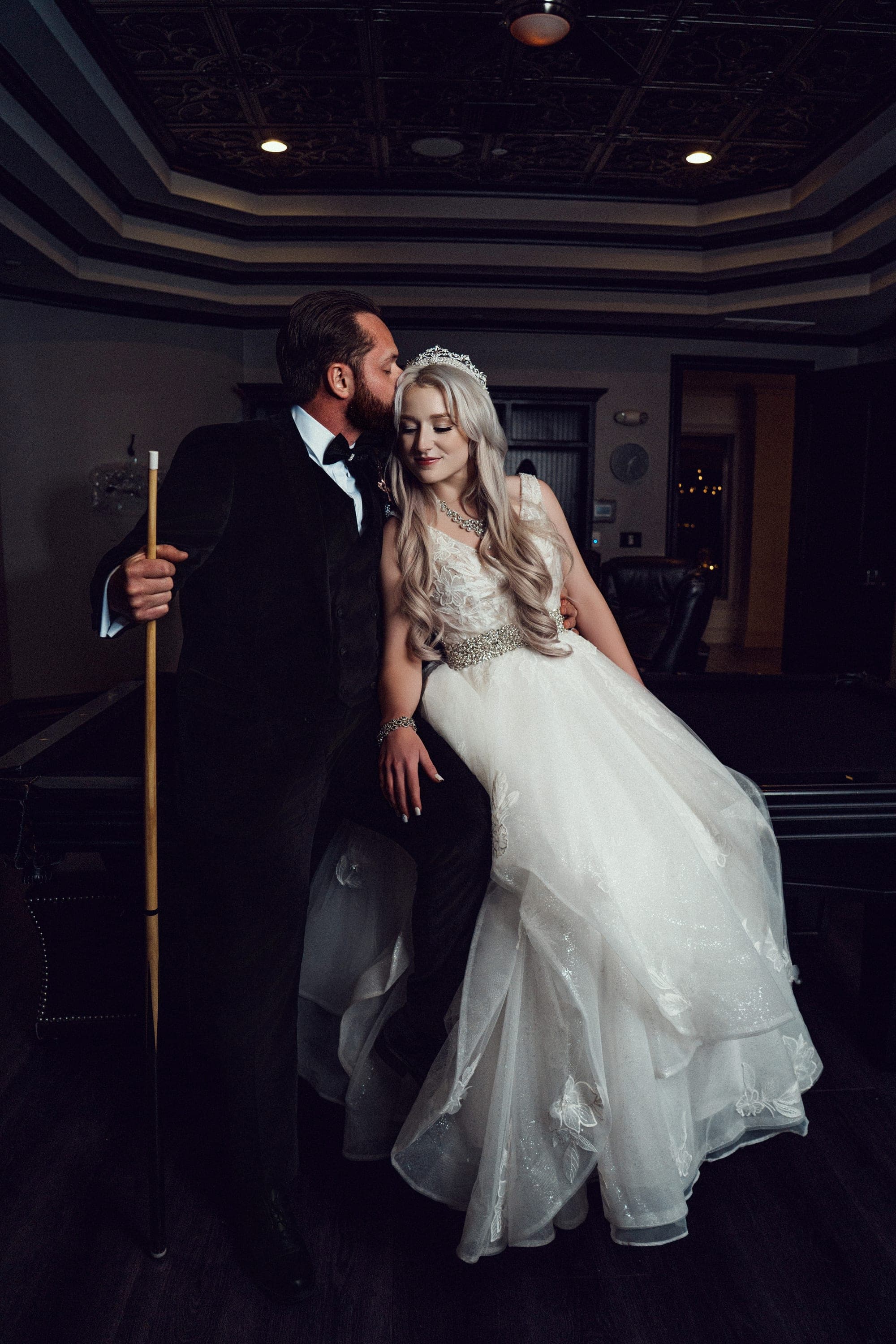 Carly and Christopher playing pool in the billiards room, her gown draped over the table rail