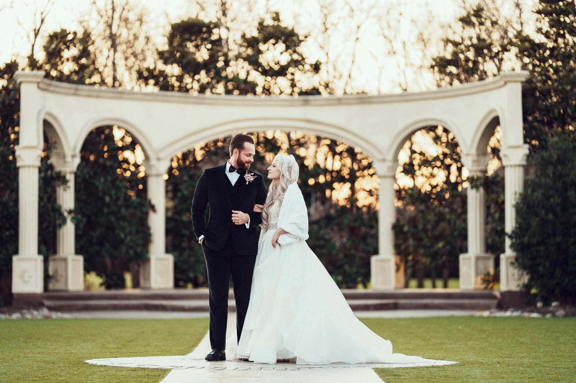A couple at sunset beneath the garden colonnade at Knotting Hill Place in Little Elm