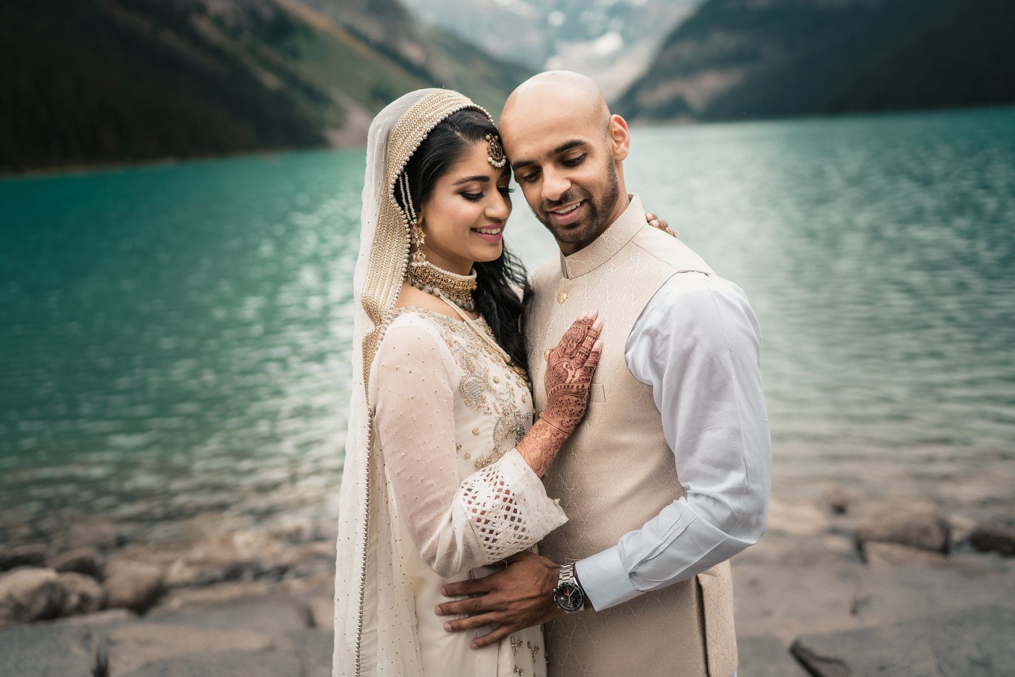 Lubna and Waqas embracing beside Lake Louise