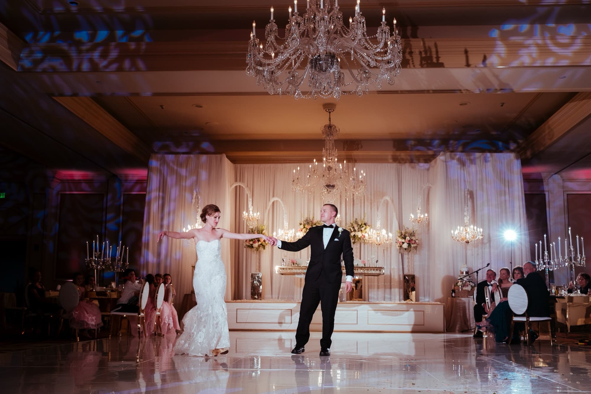 Ilana and Christopher sharing their first dance on the Langham ballroom floor beneath a crystal chandelier