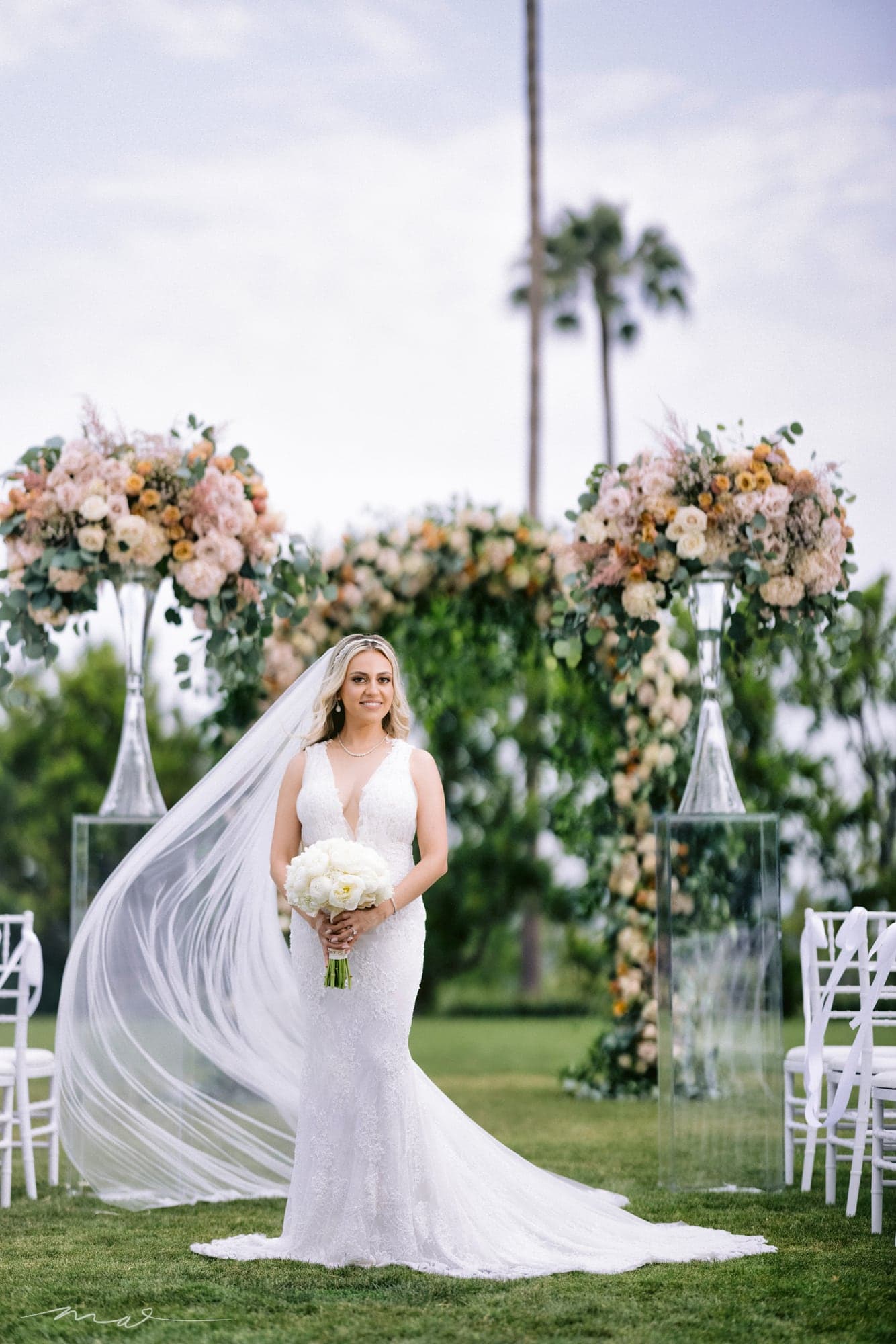 Melody beneath the floral ceremony arch