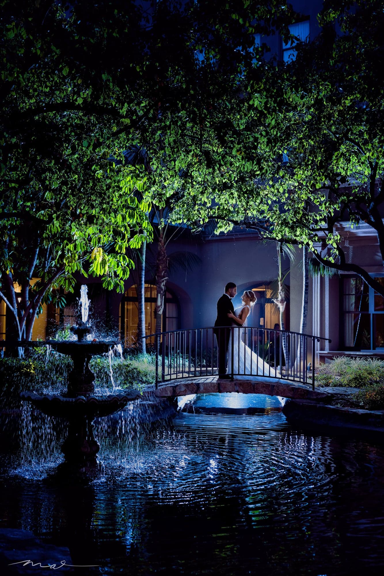 Melody and Hrand on a garden bridge at night