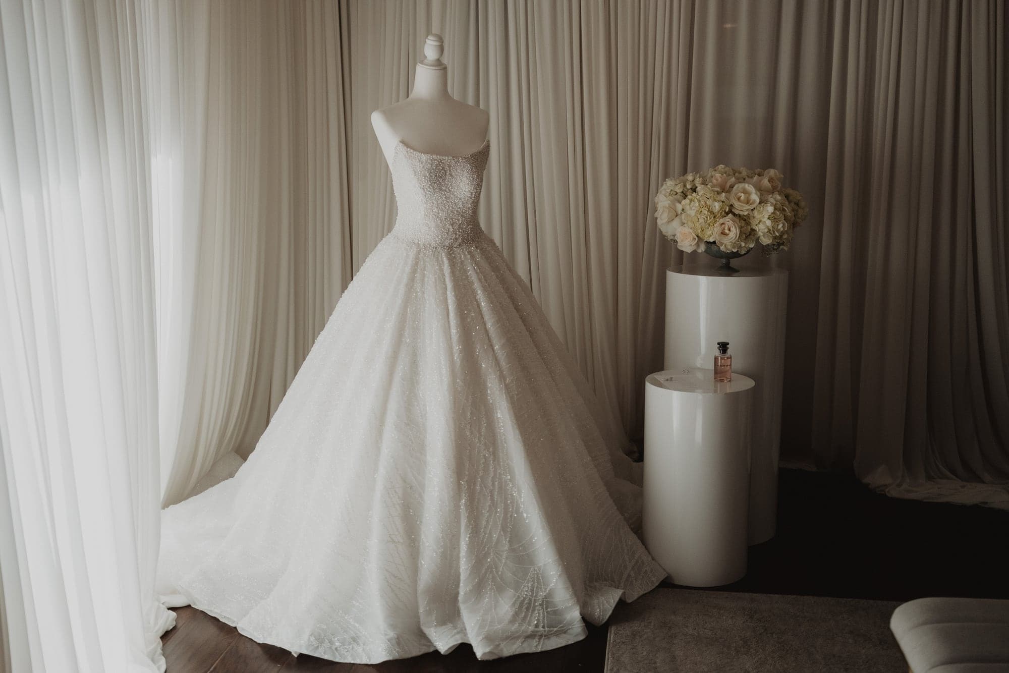 Amanda's wedding gown displayed beside white flowers