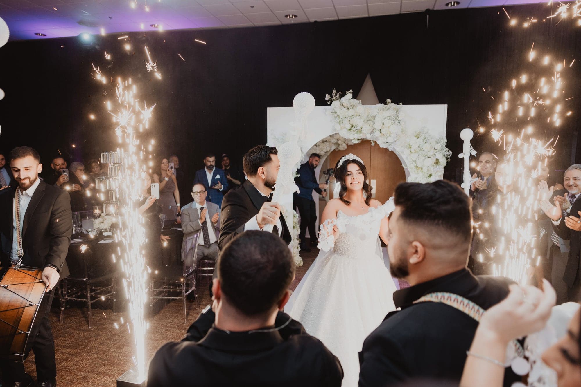 Amanda and Anthony celebrating beneath indoor sparklers