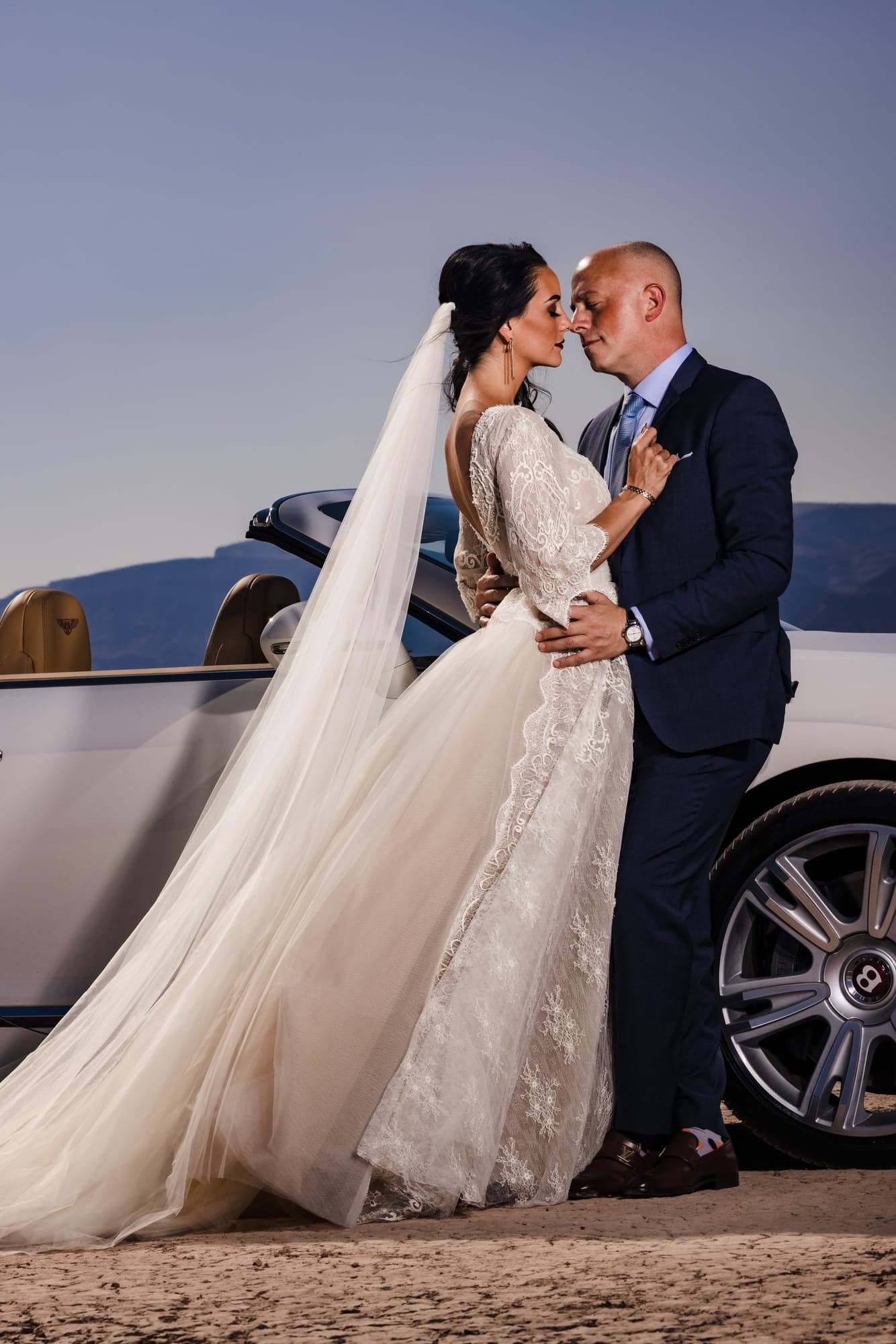 Groom beside a white Bentley in the desert