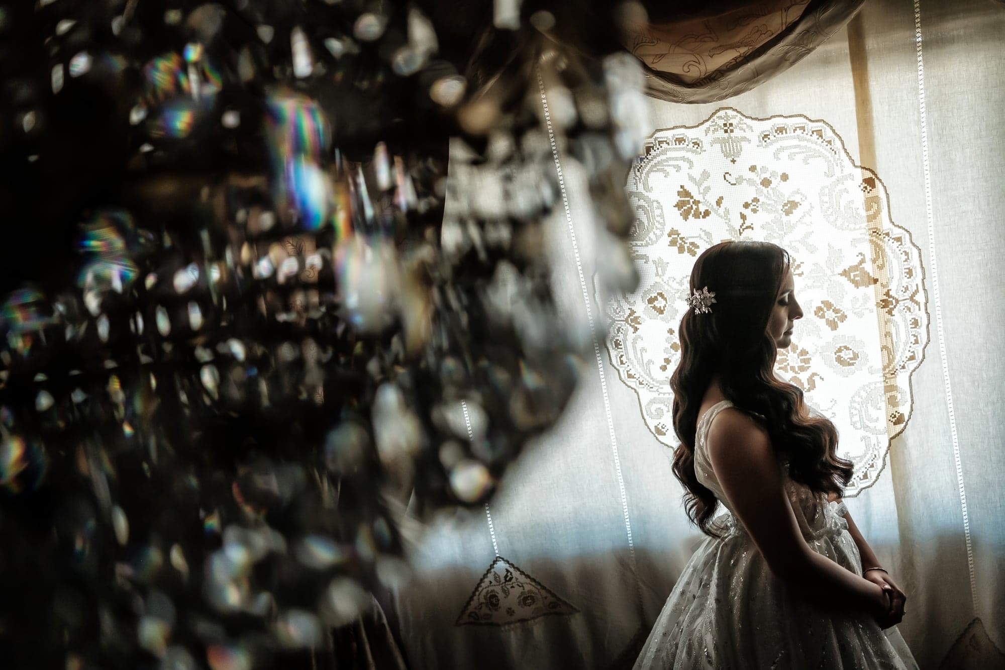 Piera standing in soft window light while preparing for her New Jersey wedding