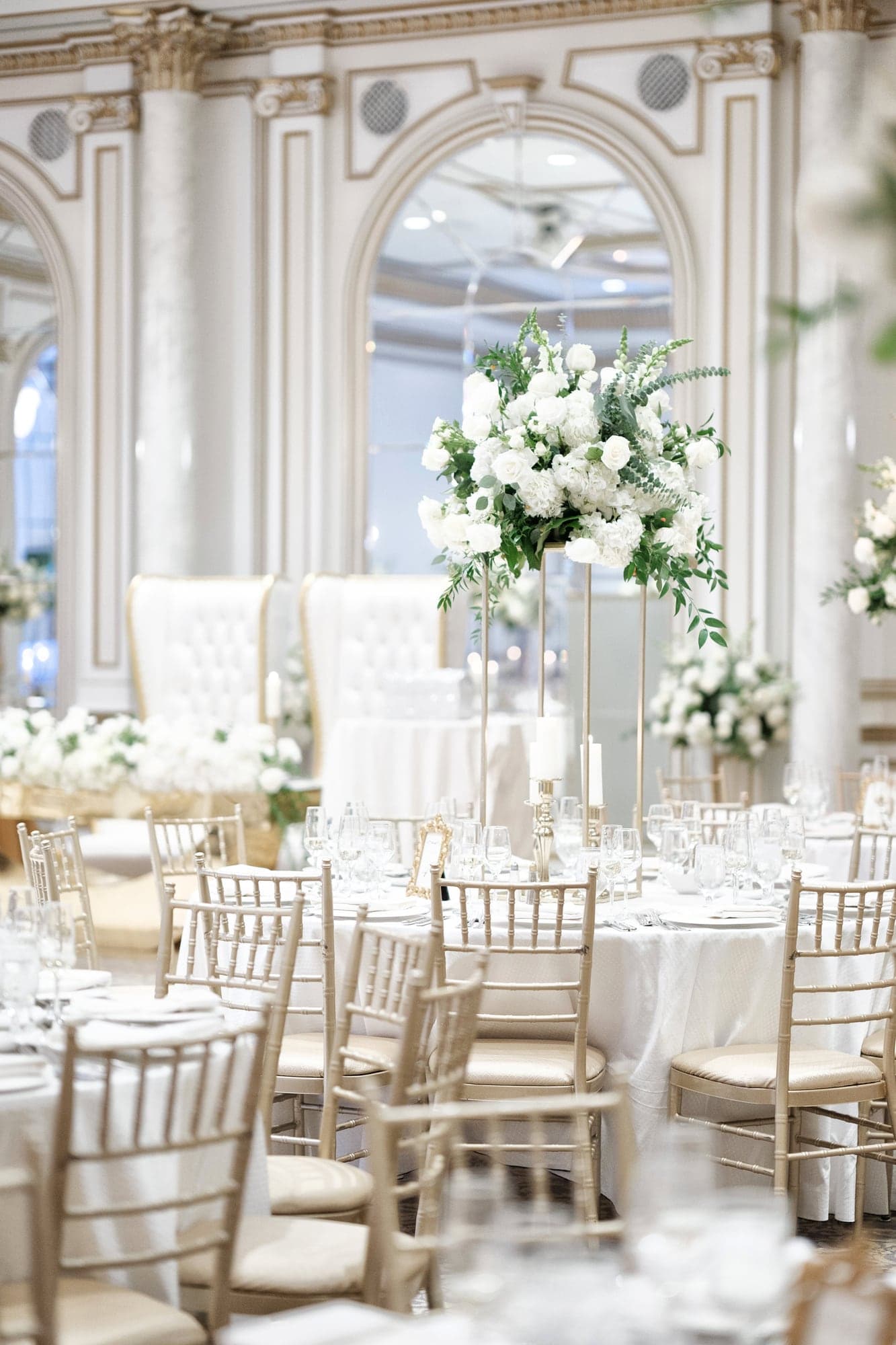 The Legacy Castle ballroom prepared with white flowers and tall crystal chandeliers