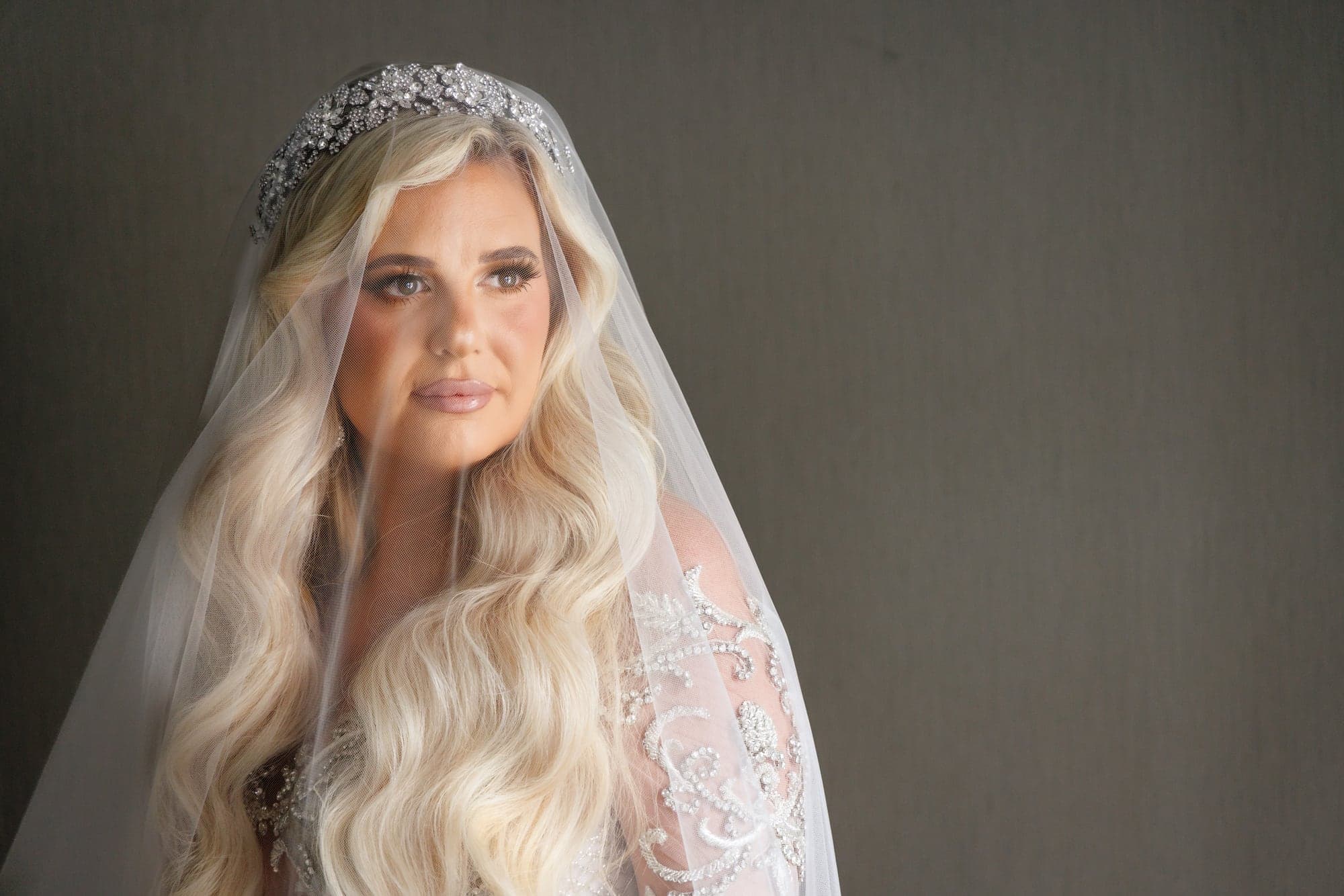 Kaitelyn in a lace gown and veil before the cathedral ceremony