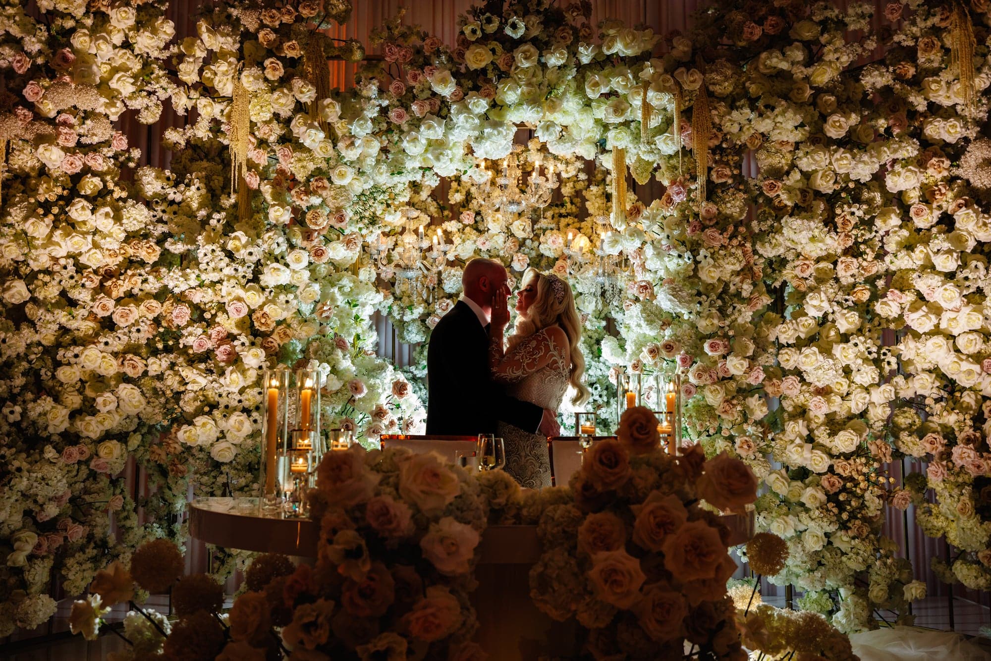 Kaitelyn and Blaise surrounded by white floral reception decor