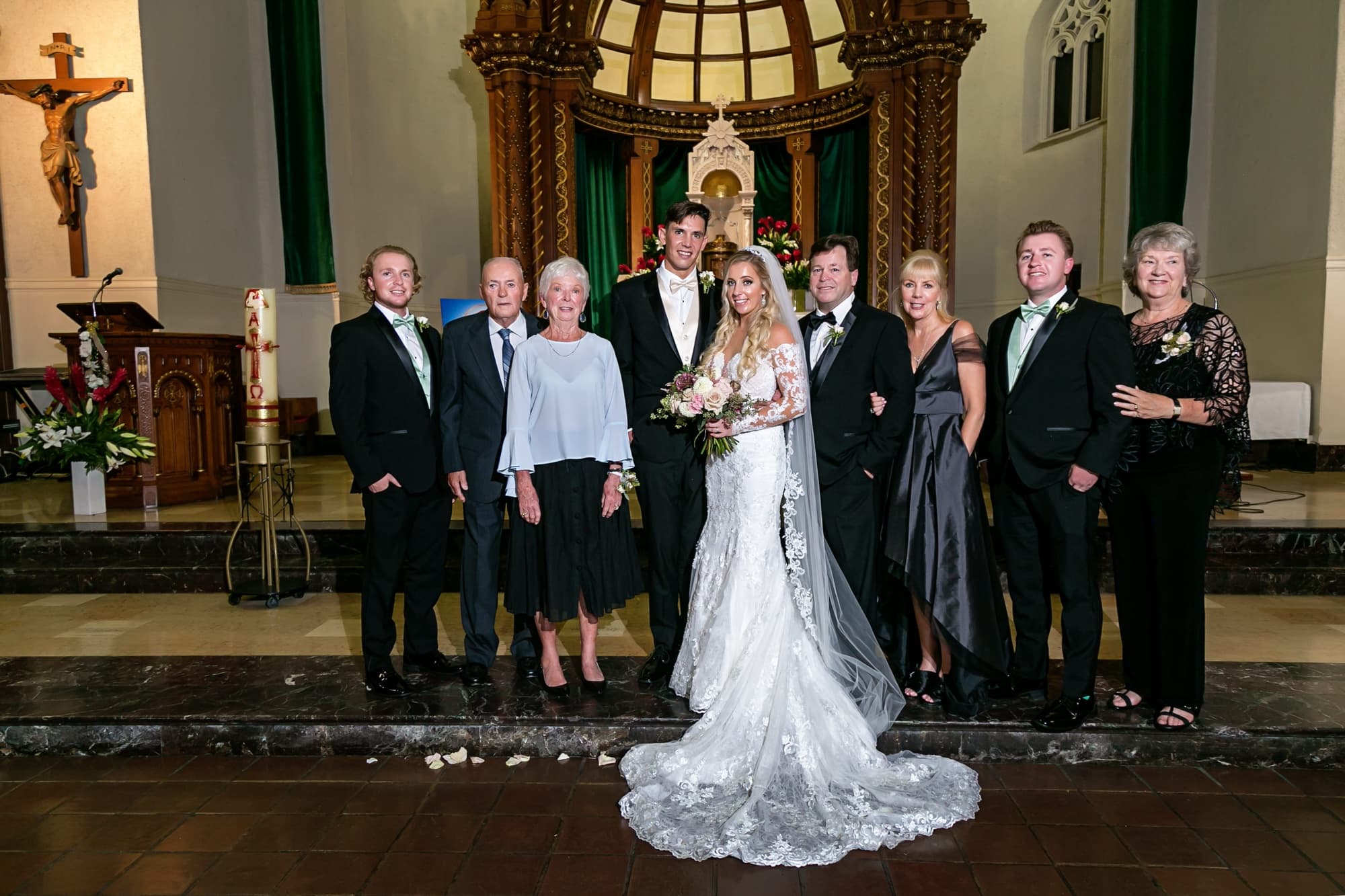 Jaymie and Matt with their families at the green and gold altar of Immaculate Conception Church in downtown Los Angeles