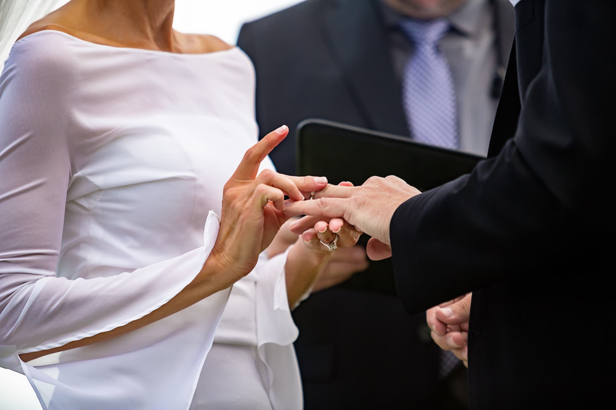 Close-up of Andrea placing the ring on John's finger during their Los Verdes wedding ceremony