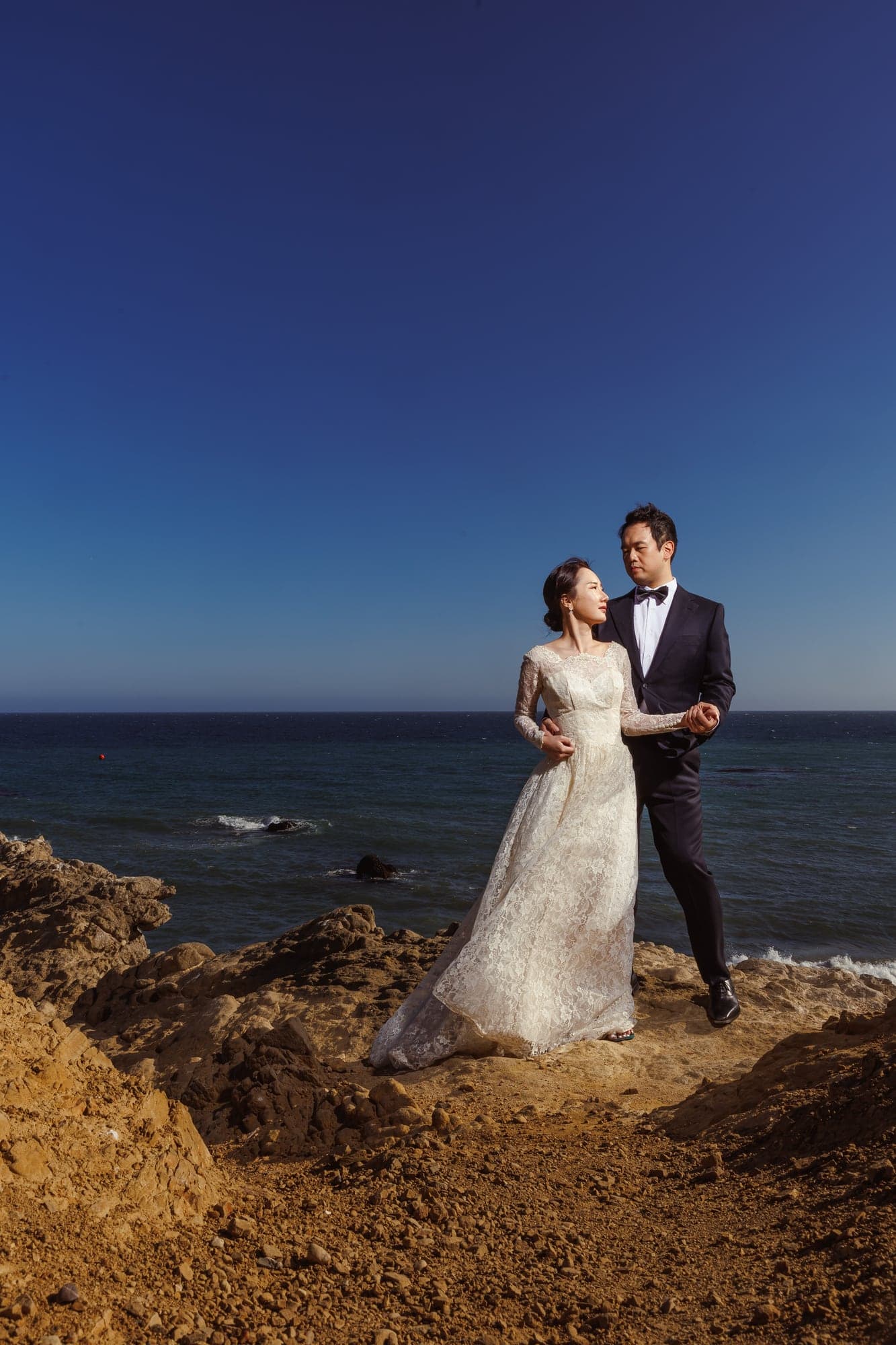 Lauren and Lee standing together beside the Malibu coast