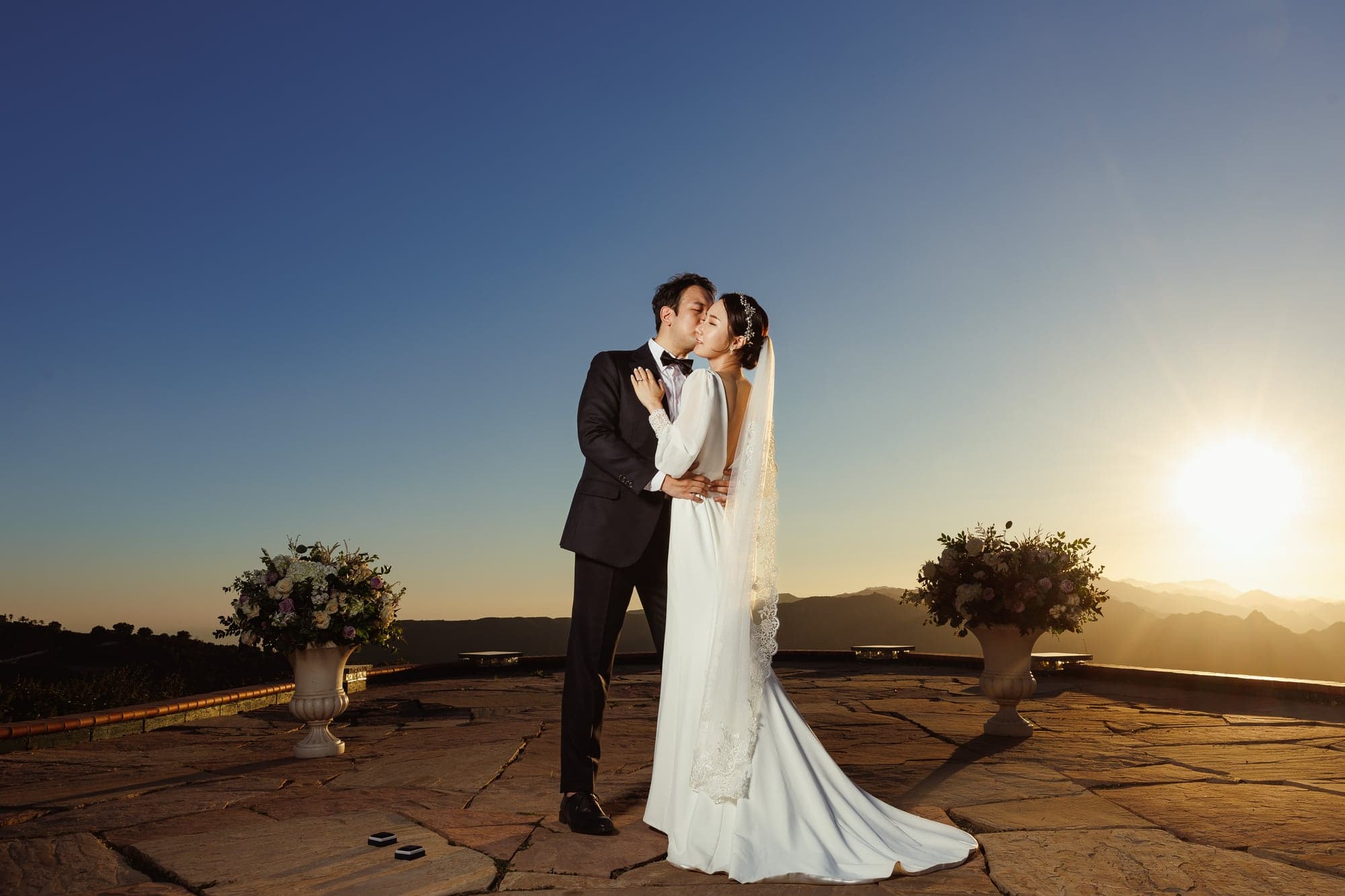 Lauren and Lee embracing in golden light above Malibu