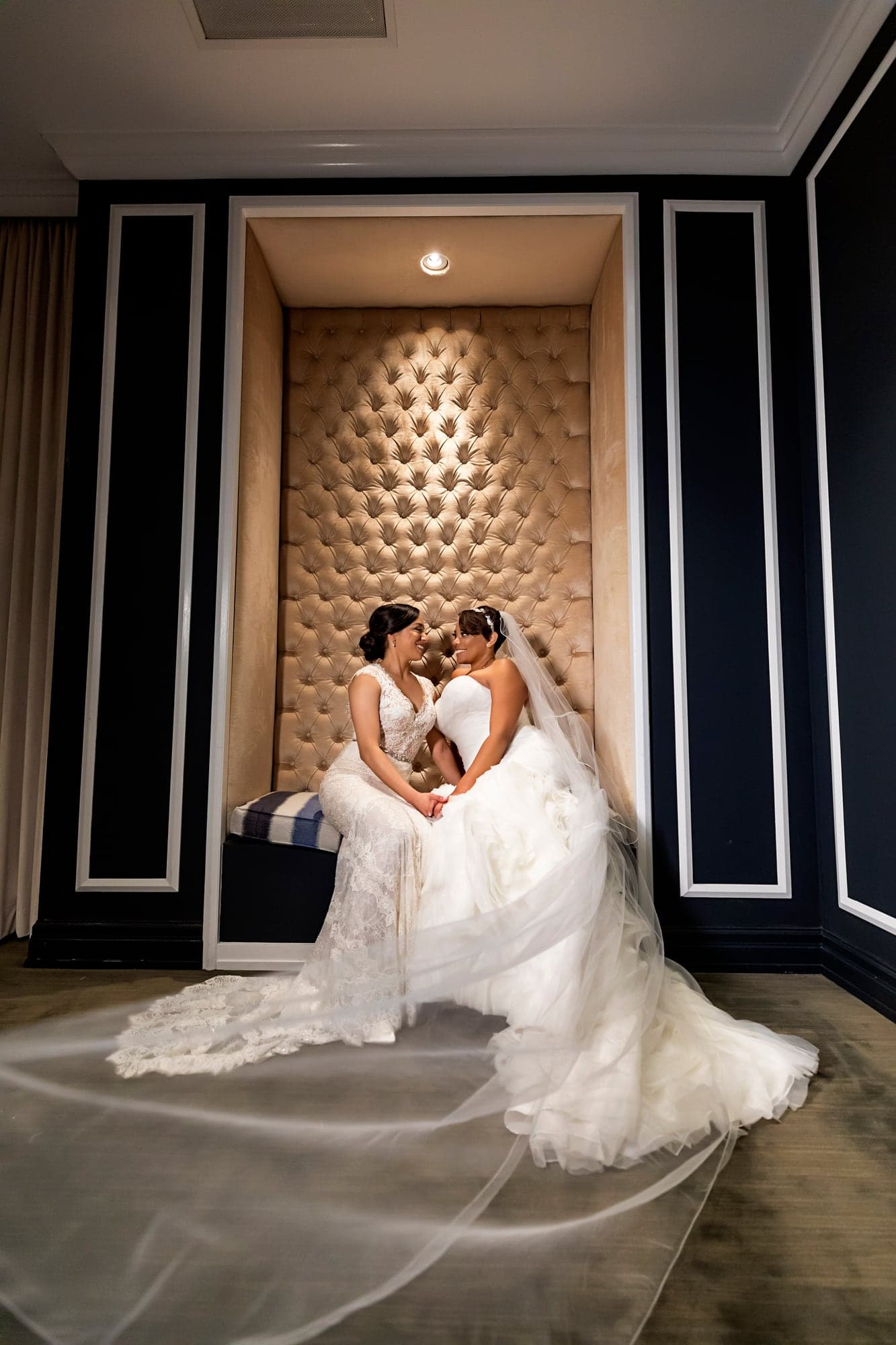 Two brides seated together in the reception room
