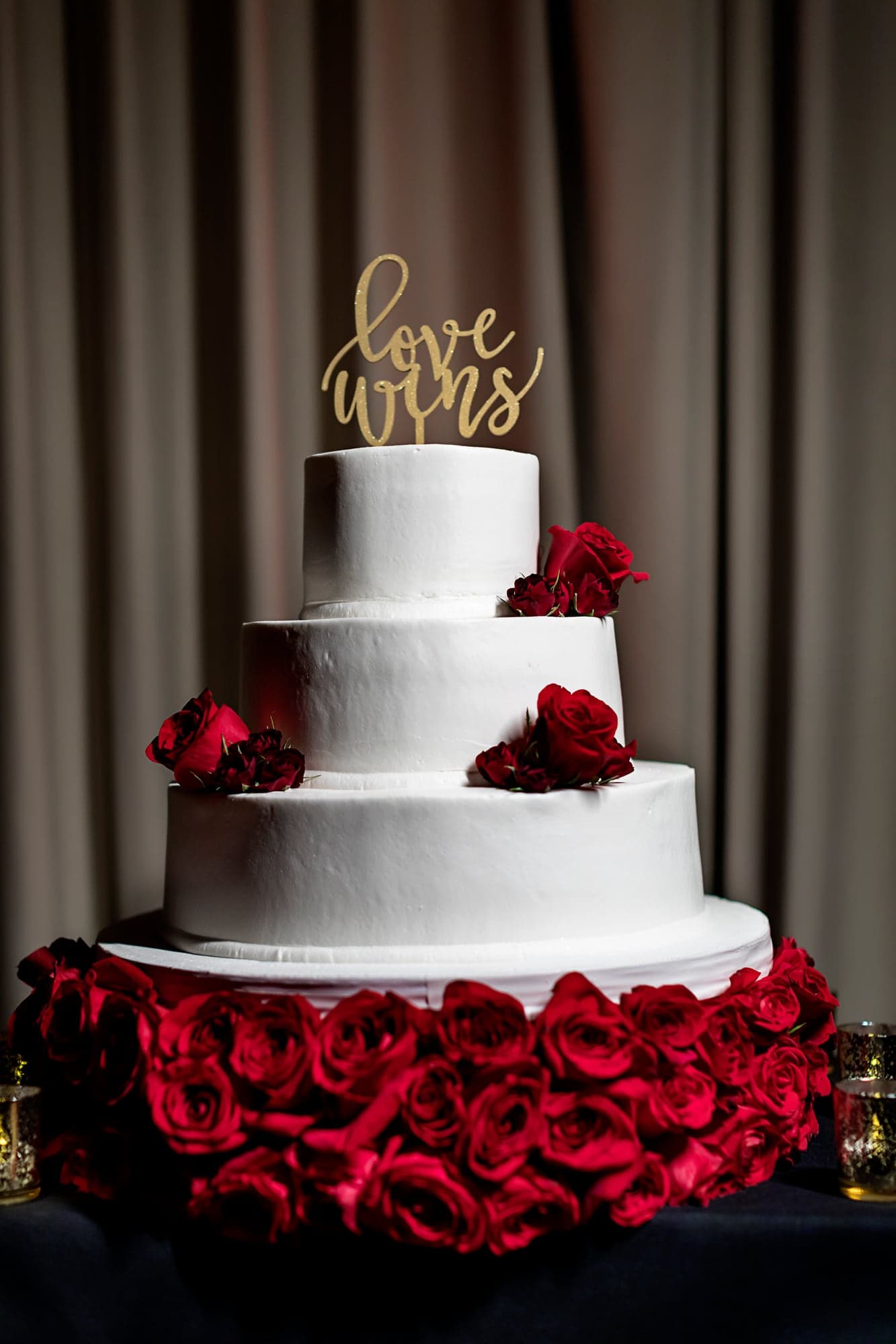 White wedding cake decorated with red roses