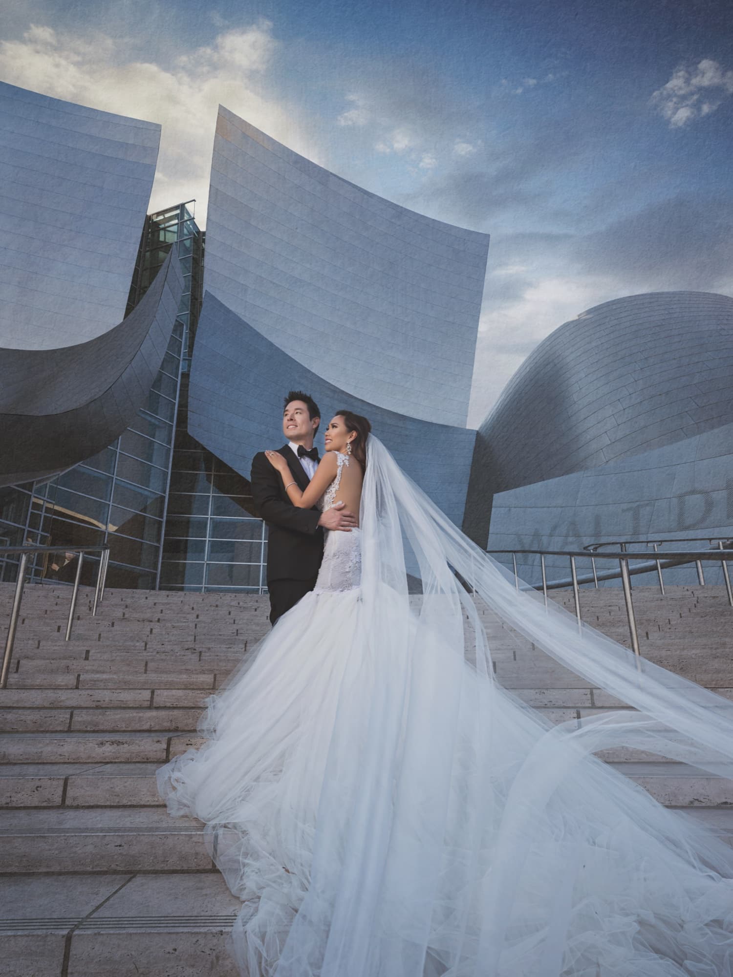 Caroline's cathedral veil spread down the steps of Walt Disney Concert Hall as Gerald holds her against the steel curves