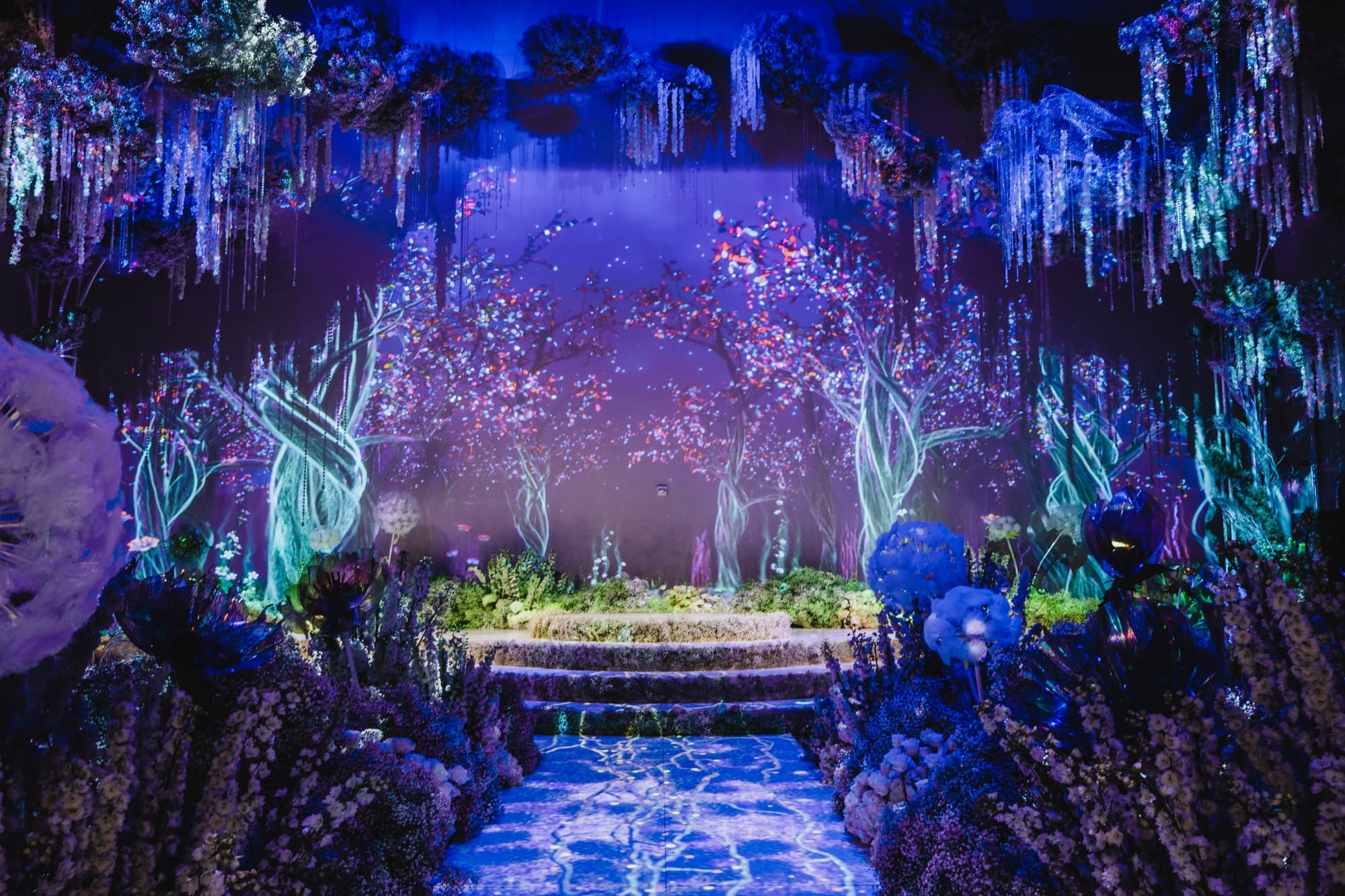 The video-mapped ceremony space at NeueHouse Hollywood glowing violet and blue like an enchanted forest