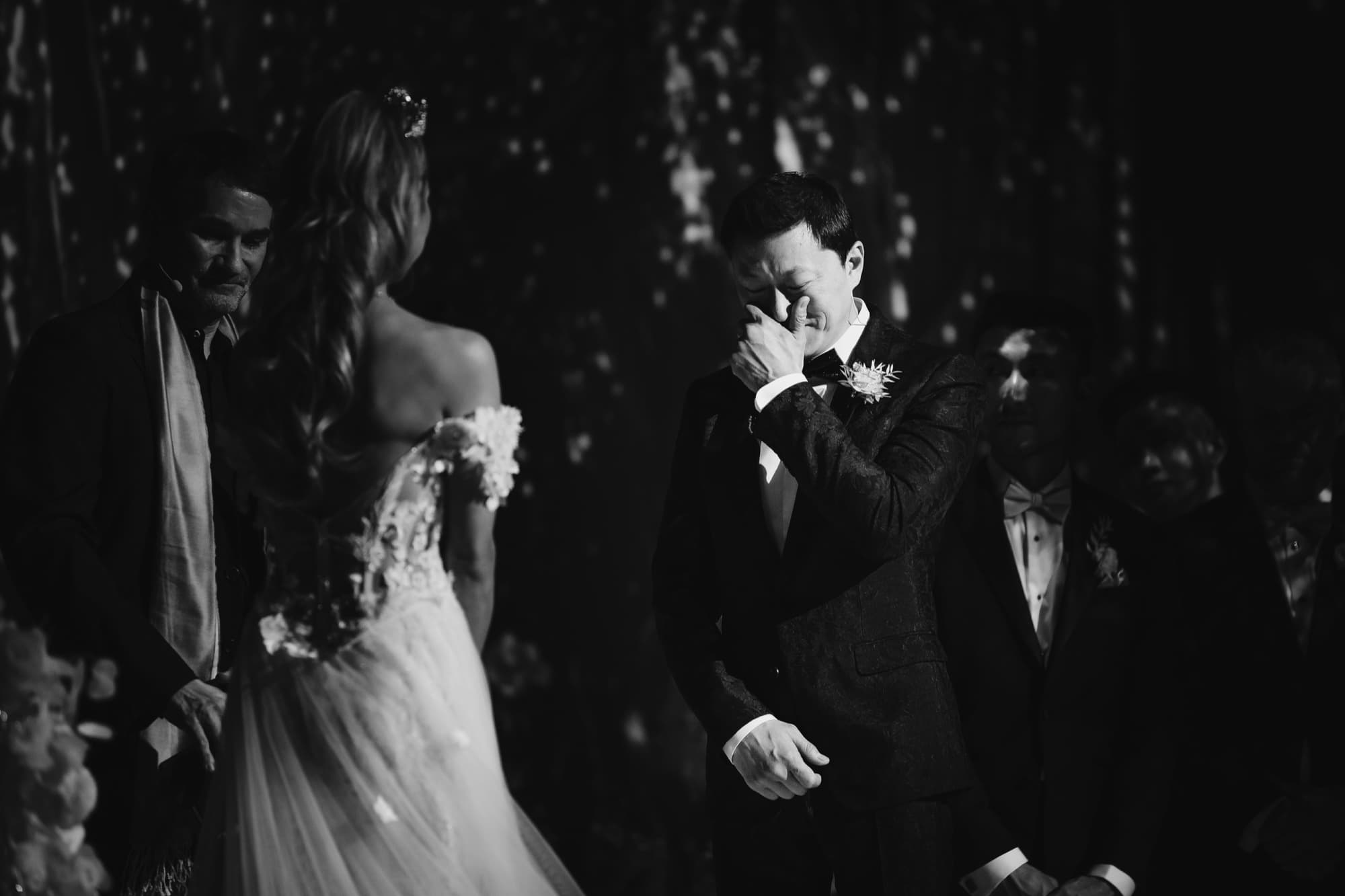 Black and white photograph of Justin overcome with emotion during the ceremony as Danielle stands before him
