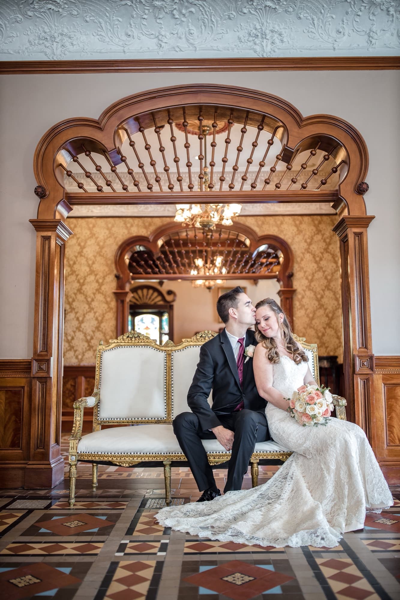 Tommy kissing Cathryn on an antique settee in the gilded Victorian parlor of Newhall Mansion